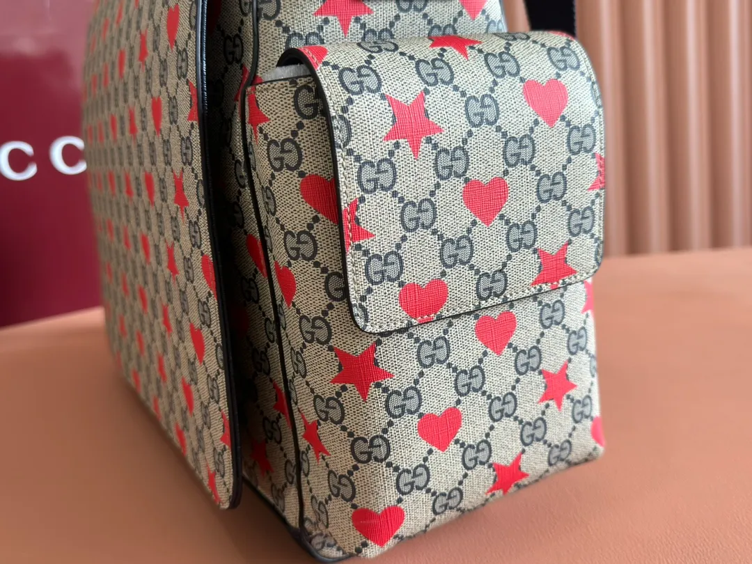 p1140. 💋💋💋"With full set of original counter gift bag packaging" [New Product] The children’s Cruise 2025 series presents a series of well-loved themes, including iconic logo details. Made from GG Supreme canvas, this diaper bag displays an all-over star and heart print and features dark blue bands. Beige and blue GG Supreme canvas. Dark blue ribbon decoration. All-over star and heart print. Washable nylon lining. Interior: 3 stretchy open pockets, 2 stretchy water bottles. Model: 811491. Size: 45x32x15cm Color: star dark blue/pvc. Made in Italy