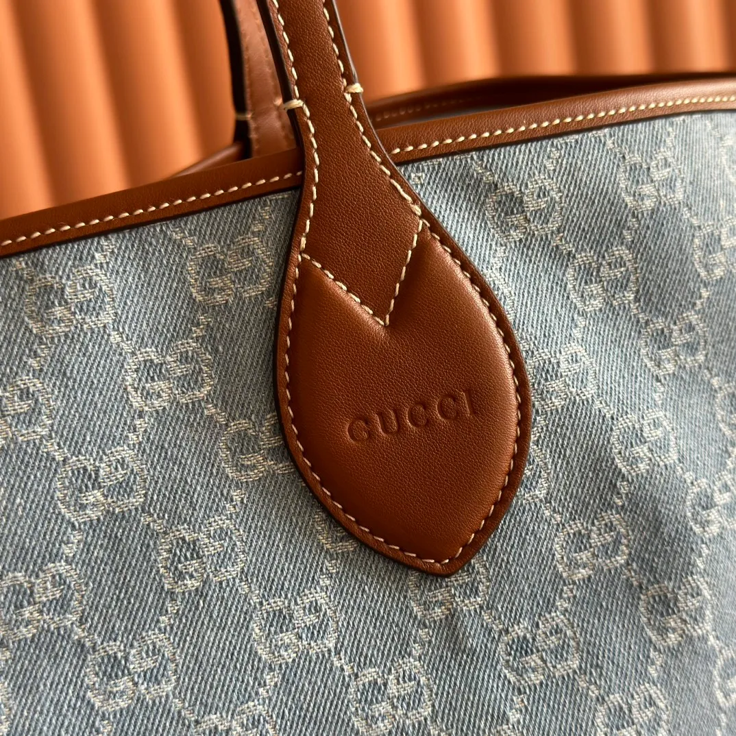 Pre-order 💋💋💋【Equipped with counter gift bag】The Gucci Totissima series combines the word "tote" with the superlative word "issima" in Italian, highlighting the practical function and timeless background of this handbag. This medium tote bag comes with a removable clutch. Blue GG denim Brown leather trim with contrasting stitching Blue cotton and linen lining Detachable clutch: 21.5 cm (W) x 12.5 cm (H) Top handle (21 cm H) Model: 820481. Dimensions: 30.5cm (width) x 28cm (height) x 27cm (depth) Color: Gray denim/original leather. Weight: approx. 0.6kg Made in Italy