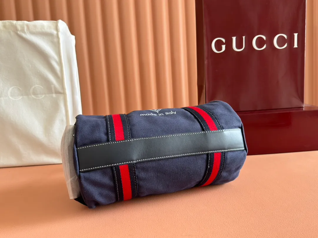 p960. 💋💋💋"With full set of original counter packaging"💕[New Product] With the theme of freedom, vitality and community, the 2025 spring and summer series newly presents a variety of travel items and men's bags, adding more fun to travel and exploration. This canvas travel bag features embellished stitching at the top, blue leather piping and a 'Gucci Made in Italy' badge printed on the front. Dark blue canvas Dark blue leather trimming "Gucci Made in Italy" and badge print Red and green webbing Top stitching detail Interior: 1 side handle Handle height: 12.5cm Adjustable webbing and canvas shoulder strap (55cm height); length adjustable from 77cm to 136cm Zip closure Ident.: 816865. Dimensions: 30cm (W) x 16cm (H) x 15cm (D) Weight: Approx. 0.54kg Color: Dark blue canvas. Made in Italy