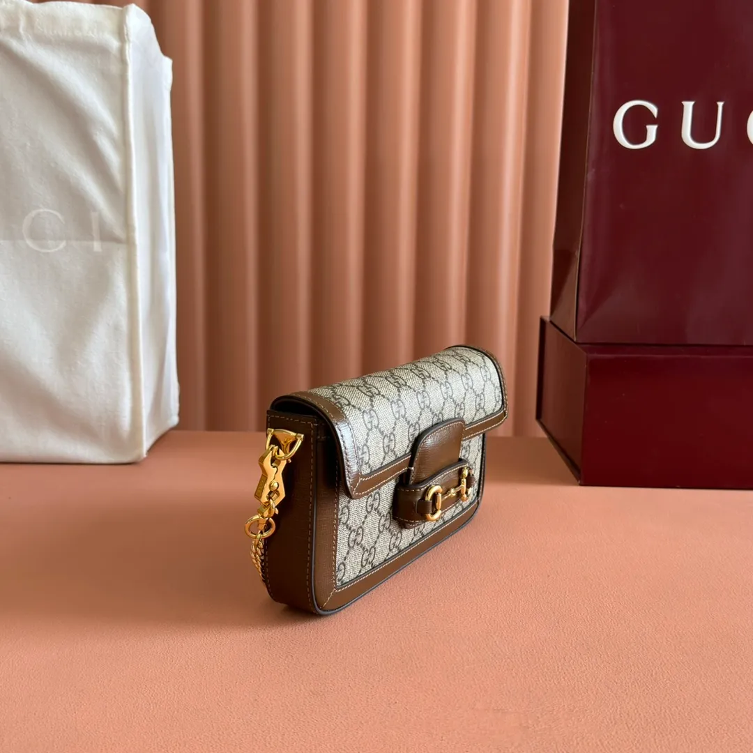 p1120. 💋💋💋【Original leather accessories🌈(Cdfmall Sanya Duty Free Shop Handbag)🔥🔥 Gucci Horsebit 1955 series mini handbag. Gucci Horsebit The 1955 series draws inspiration from the brand’s archive designs, incorporating modern essence into early design details from more than 60 years ago. The design of the horsebit element is inspired by the brand’s equestrian roots. It consists of two elements: a double ring and a long bar. It has become one of the brand’s most recognizable iconic elements. This mini handbag comes with a detachable card pocket and is versatile in beige and ebony. Supreme canvas, brown leather trim, gold-tone hardware, mini bag: suede-like microfiber lining; card pocket: moiré fabric lining, horsebit closure, detachable card pocket with zipper closure, interior: two compartments, chain shoulder strap (42cm high) with flap closure. Model number: 752002. Dimensions: 21.5(L) x 12.5(W) x 3cm(D) Card pocket: 8.5cm (length) x 19.5cm (width) Color: brown/pvc Made in Italy.