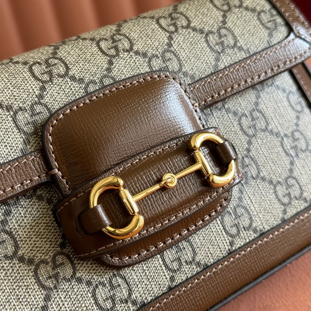 p1120. 💋💋💋【Original leather accessories🌈(Cdfmall Sanya Duty Free Shop Handbag)🔥🔥 Gucci Horsebit 1955 series mini handbag. Gucci Horsebit The 1955 series draws inspiration from the brand’s archive designs, incorporating modern essence into early design details from more than 60 years ago. The design of the horsebit element is inspired by the brand’s equestrian roots. It consists of two elements: a double ring and a long bar. It has become one of the brand’s most recognizable iconic elements. This mini handbag comes with a detachable card pocket and is versatile in beige and ebony. Supreme canvas, brown leather trim, gold-tone hardware, mini bag: suede-like microfiber lining; card pocket: moiré fabric lining, horsebit closure, detachable card pocket with zipper closure, interior: two compartments, chain shoulder strap (42cm high) with flap closure. Model number: 752002. Dimensions: 21.5(L) x 12.5(W) x 3cm(D) Card pocket: 8.5cm (length) x 19.5cm (width) Color: brown/pvc Made in Italy.