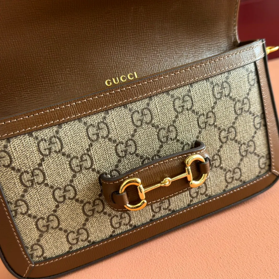 p1120. 💋💋💋【Original leather accessories🌈(Cdfmall Sanya Duty Free Shop Handbag)🔥🔥 Gucci Horsebit 1955 series mini handbag. Gucci Horsebit The 1955 series draws inspiration from the brand’s archive designs, incorporating modern essence into early design details from more than 60 years ago. The design of the horsebit element is inspired by the brand’s equestrian roots. It consists of two elements: a double ring and a long bar. It has become one of the brand’s most recognizable iconic elements. This mini handbag comes with a detachable card pocket and is versatile in beige and ebony. Supreme canvas, brown leather trim, gold-tone hardware, mini bag: suede-like microfiber lining; card pocket: moiré fabric lining, horsebit closure, detachable card pocket with zipper closure, interior: two compartments, chain shoulder strap (42cm high) with flap closure. Model number: 752002. Dimensions: 21.5(L) x 12.5(W) x 3cm(D) Card pocket: 8.5cm (length) x 19.5cm (width) Color: brown/pvc Made in Italy.