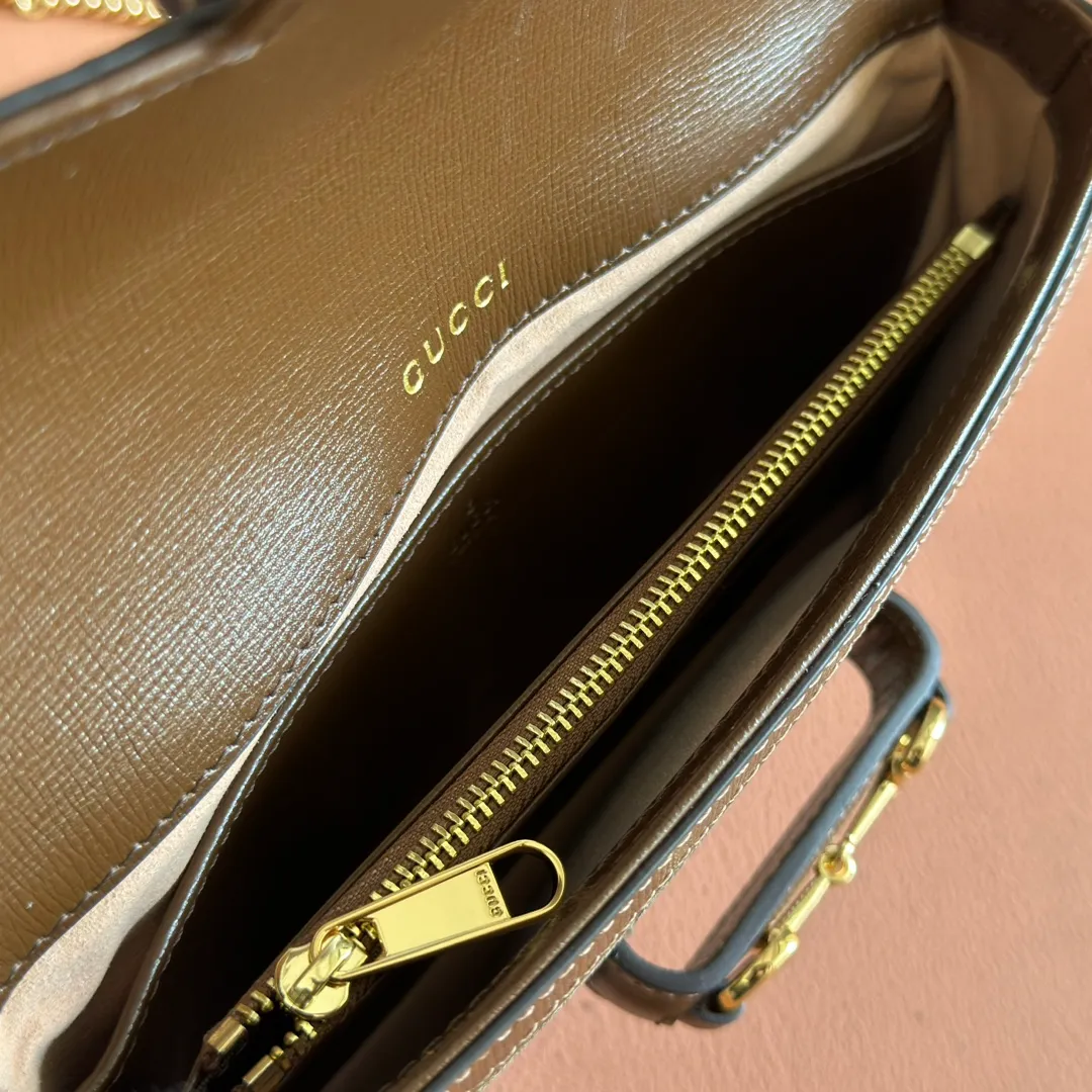 p1120. 💋💋💋【Original leather accessories🌈(Cdfmall Sanya Duty Free Shop Handbag)🔥🔥 Gucci Horsebit 1955 series mini handbag. Gucci Horsebit The 1955 series draws inspiration from the brand’s archive designs, incorporating modern essence into early design details from more than 60 years ago. The design of the horsebit element is inspired by the brand’s equestrian roots. It consists of two elements: a double ring and a long bar. It has become one of the brand’s most recognizable iconic elements. This mini handbag comes with a detachable card pocket and is versatile in beige and ebony. Supreme canvas, brown leather trim, gold-tone hardware, mini bag: suede-like microfiber lining; card pocket: moiré fabric lining, horsebit closure, detachable card pocket with zipper closure, interior: two compartments, chain shoulder strap (42cm high) with flap closure. Model number: 752002. Dimensions: 21.5(L) x 12.5(W) x 3cm(D) Card pocket: 8.5cm (length) x 19.5cm (width) Color: brown/pvc Made in Italy.