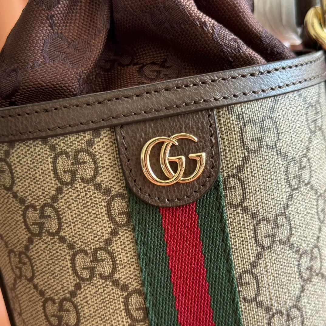 p1000💋💋💋"With full set of original counter packaging" [New Product] The Ophidia series ingeniously interprets novel silhouettes and functions, with iconic beige and brown colors, creating a bag with soft texture and fashionable style. This bucket bag features a top handle and a shoulder strap. Beige and dark brown GG monogram coated fabric Gucci Rosso Ancora leather trim Light gold tone hardware Gucci Ancora taffeta lining and green cotton linen lining Double G webbing handles (12 cm high) removable and adjustable leather shoulder strap (52 cm high) drawstring fly Ident: 838462. Dimensions: 11.5cm (width) x 23cm (height) x 8cm (depth) Weight: approx. 312g Color: brown/PVC. Made in Italy
