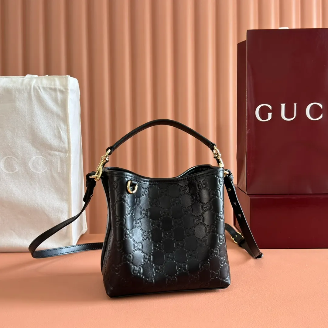 p1140. 💋💋💋Original leather configuration with full counter packaging [New product] GG Emblem series reinterprets the brand's timeless elegance and exquisite craftsmanship. Lined in webbed cotton, this bucket bag features an internal compartment for added functionality. Black GG printed embossed leather Light gold tone hardware Black cotton and linen blend lining Top handle with hook closure (height: 14cm) Additional D-ring for attaching removable items Interior: two compartments and a central snap-stud compartment Detachable and adjustable leather shoulder strap (height: 52cm - 57.5cm; length: 107cm - 114cm) Magnetic snap closure Ident No.: 815118. Dimensions: 19cm (width) x 18cm (height) x 11cm (depth) Weight: approx. 0.45kg Color: black embossed/original leather. Made in Italy