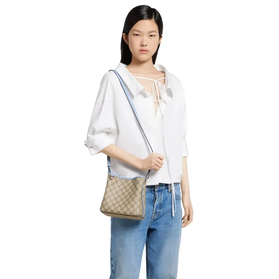 💕💕The GG Emblem series reinterprets the brand’s timeless elegance and exquisite craftsmanship. This bucket bag is lined in webbed cotton and features an internal compartment for added functionality. New GG monogram coated fabric in beige and dark brown Light blue leather trim Light gold tone hardware Red and green web cotton lining The bag pictured is sold separately and does not come with the bag charm. Top handle with hook closure (height: 14 cm) Additional D-ring for attaching removable items Interior: two compartments and a central snap-stud compartment Removable and adjustable leather shoulder strap (height: 52 cm - 57.5 cm; length: 107 cm - 114 cm) Magnetic snap closure Ident.: 815118. Dimensions: 19 cm (width) x 18 cm (height) x 11 cm (depth) Weight: about 0.45 kg Color: brown pvc/original leather. Made in Italy