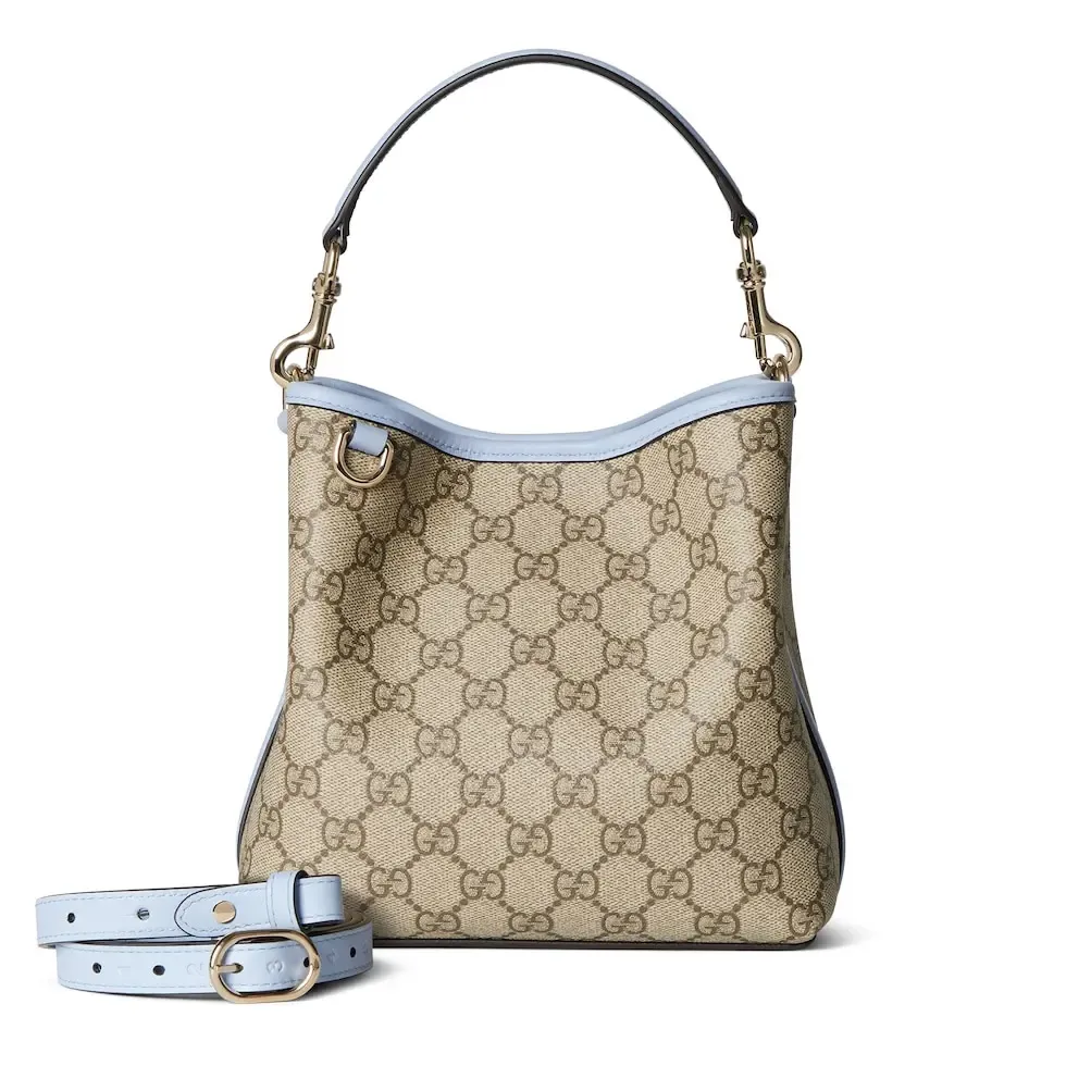 💕💕The GG Emblem series reinterprets the brand’s timeless elegance and exquisite craftsmanship. This bucket bag is lined in webbed cotton and features an internal compartment for added functionality. New GG monogram coated fabric in beige and dark brown Light blue leather trim Light gold tone hardware Red and green web cotton lining The bag pictured is sold separately and does not come with the bag charm. Top handle with hook closure (height: 14 cm) Additional D-ring for attaching removable items Interior: two compartments and a central snap-stud compartment Removable and adjustable leather shoulder strap (height: 52 cm - 57.5 cm; length: 107 cm - 114 cm) Magnetic snap closure Ident.: 815118. Dimensions: 19 cm (width) x 18 cm (height) x 11 cm (depth) Weight: about 0.45 kg Color: brown pvc/original leather. Made in Italy