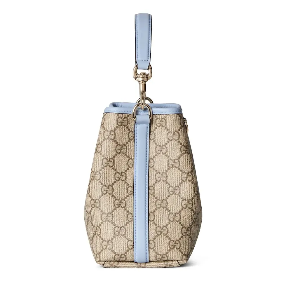 💕💕The GG Emblem series reinterprets the brand’s timeless elegance and exquisite craftsmanship. This bucket bag is lined in webbed cotton and features an internal compartment for added functionality. New GG monogram coated fabric in beige and dark brown Light blue leather trim Light gold tone hardware Red and green web cotton lining The bag pictured is sold separately and does not come with the bag charm. Top handle with hook closure (height: 14 cm) Additional D-ring for attaching removable items Interior: two compartments and a central snap-stud compartment Removable and adjustable leather shoulder strap (height: 52 cm - 57.5 cm; length: 107 cm - 114 cm) Magnetic snap closure Ident.: 815118. Dimensions: 19 cm (width) x 18 cm (height) x 11 cm (depth) Weight: about 0.45 kg Color: brown pvc/original leather. Made in Italy