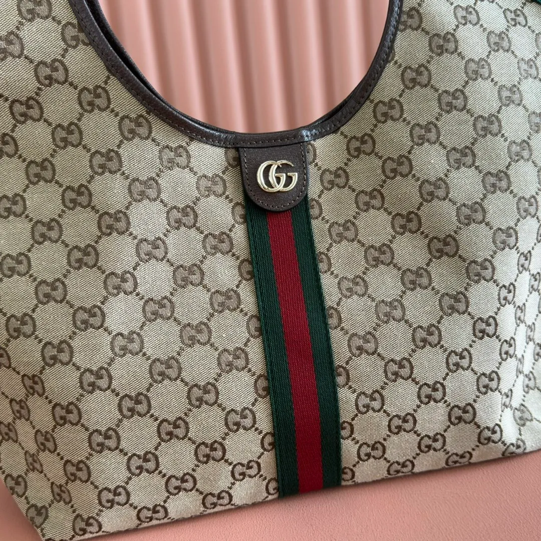 p1060. 💋💋💋"With full set of original counter packaging" [New Product] The Gucci Giglio series is newly unveiled at the Florence 2026 early spring fashion show, paying tribute to the brand's Italian roots and integrating timeless heritage and innovative spirit. This spacious tote bag is crafted in GG canvas, embellished with webbing piping and comes with a detachable clutch. Off-white and dark brown GG canvas, trimmed with red and green webbing, green cotton lining, Double G, with detachable clutch, magnetic buckle closure, model number: 853972. Dimensions: 50cm (width) x 47cm (height) x 14cm (d) Color: apricot/brown. Made in Italy