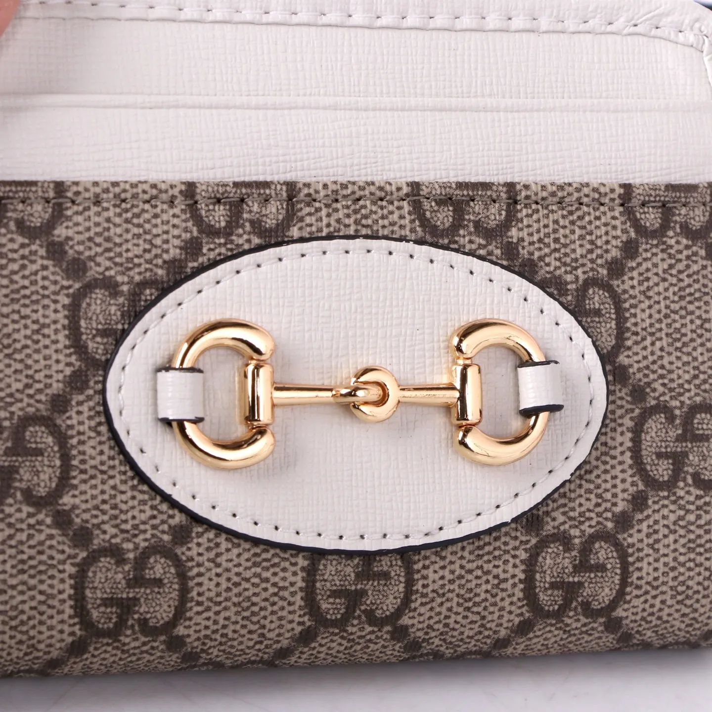 💰150 Style No. GA103 Brand: GUCCl Color: Brown White Size: 11.5*8.5*3 Description: In the 2021 spring and summer series, the Gucci 1955 horsebit card holder made of GG Supreme high-grade artificial canvas and brown leather is newly launched. This series adopts the same double-ring and long strip design as the handbags. This detail is inspired by the brand’s equestrian roots. It is one of Gucci’s classic heritage and one of the brand’s most representative symbolic elements.