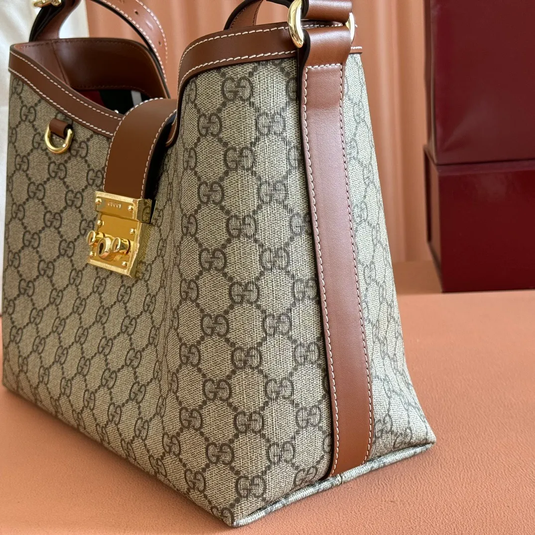 p1120💋💋💋【Full set of packaging at the counter】The Padlock series has launched a variety of fashionable bags with various carrying methods, adding color to the 2025 early autumn series. This shoulder bag features a central compartment with a zip pocket and is lined with webbing, reminiscent of the brand's signature pattern. Beige and dark brown GG monogram coated fabric Brown leather trim Light gold tone hardware Red and green web cotton lining Interior: Middle compartment with zip pocket Adjustable shoulder strap (44 cm high) Padlock closure with leather keychain Ref.: 839021. Dimensions: 29 cm (width) x 23.5 cm (height) x 15.5 cm (depth) Weight: about 0.75 kg Color: Brown PVC/original leather. Made in Italy