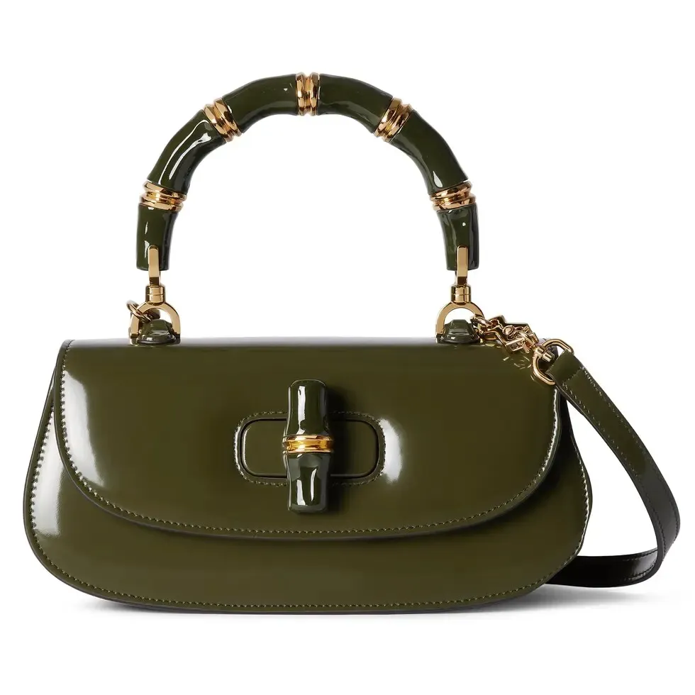 This small tote reinterprets the iconic bamboo accessory with enamel and brass details, adding another eye-catching addition to the Spring/Summer 2025 collection. Forest green glossy polished leather Bamboo enamel hardware with brass detail Three-level baffle compartments Forest green leather lining Interior: One zip pocket and mirror with removable pocket Handle height 10 cm Removable and adjustable leather shoulder strap (50 cm high); length adjustable between 100 cm and 116 cm Bamboo lock closure Ident: 827750. Dimensions: 26.6 cm (width) x 13 cm (height) x 8 cm (depth) Weight: approximately 0.9 kg Color: Forest green leather/original leather. Made in Italy