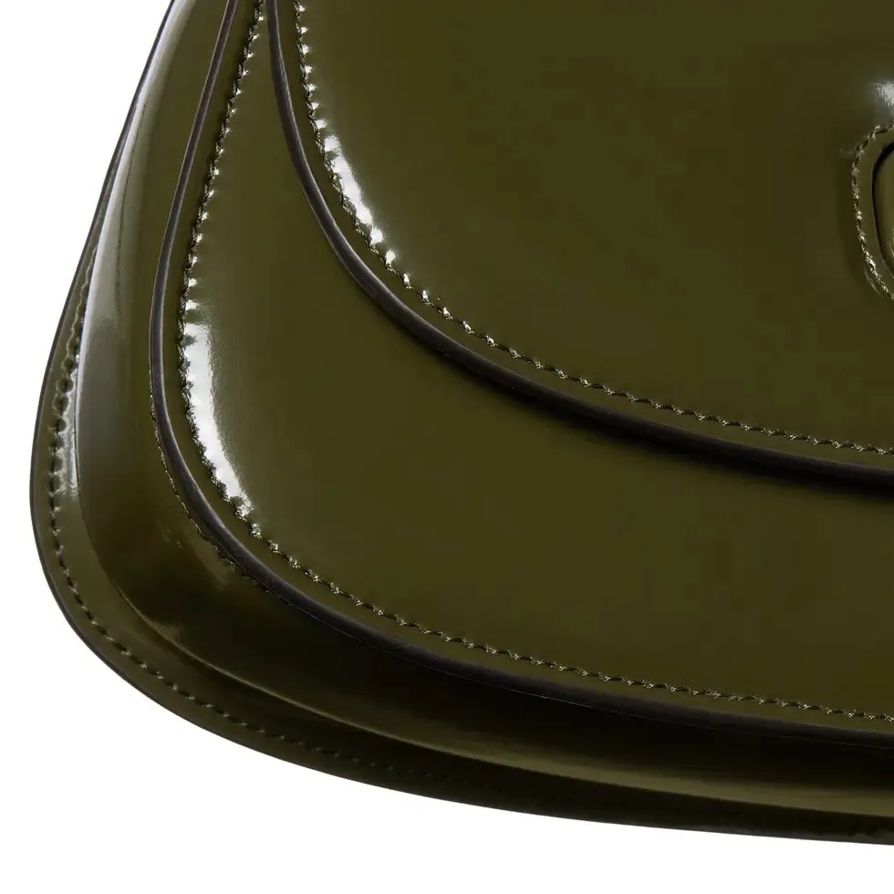 This small tote reinterprets the iconic bamboo accessory with enamel and brass details, adding another eye-catching addition to the Spring/Summer 2025 collection. Forest green glossy polished leather Bamboo enamel hardware with brass detail Three-level baffle compartments Forest green leather lining Interior: One zip pocket and mirror with removable pocket Handle height 10 cm Removable and adjustable leather shoulder strap (50 cm high); length adjustable between 100 cm and 116 cm Bamboo lock closure Ident: 827750. Dimensions: 26.6 cm (width) x 13 cm (height) x 8 cm (depth) Weight: approximately 0.9 kg Color: Forest green leather/original leather. Made in Italy