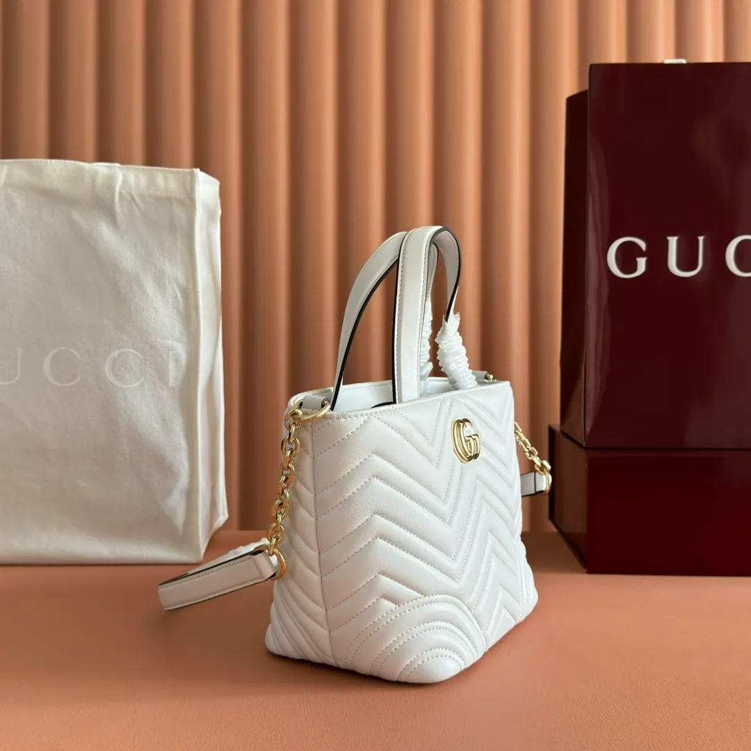 p1280. 💋💋💋 Comes with a complete set of original counter packaging [New product] This tote bag injects novel charm into the GG Marmont series with a new silhouette in the 2025 autumn and winter series. It can transform from a structural tote bag to a soft-lined bucket bag. The shape is paired with top handles and chain shoulder straps, presenting a variety of fashion styling options. White chevron quilted sheepskin Light gold-tone hardware Gucci ankara red viscose lining Double G Interior: Open pocket Handle drop 11 cm Shoulder strap drop 53 cm (bag closed: 45 cm) Ident.: 847386. Dimensions: 18cm (bottom width) x 29cm (top width) x 18cm (height) x 12.5cm (depth) Weight: approx. 0.4kg Color: White sheepskin. Made in Italy