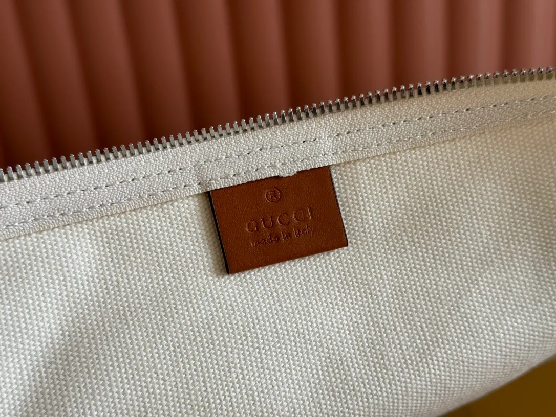 p1060. 💋💋💋"With a complete set of original counter gift bag packaging"💕[New Product] With the theme of freedom, vitality and community, the 2025 spring and summer series has newly presented a variety of travel items and men's bags, adding more fun to travel and exploration. This canvas travel bag features embellished stitching at the top, tonal leather piping and a 'Gucci Made in Italy' badge printed on the front. Off-white canvas Off-white leather trim "Gucci Made in Italy" and badge print Red and blue web Interior: 1 side handle Handle height: 24 cm Adjustable web canvas shoulder strap (55 cm high); length adjustable from 82 cm to 138 cm Zip closure Ident: 816866. Dimensions: 54cm (W) x 24cm (H) x 24cm (D) Weight: Approx. 0.985kg Colour: Off-white canvas. Made in Italy