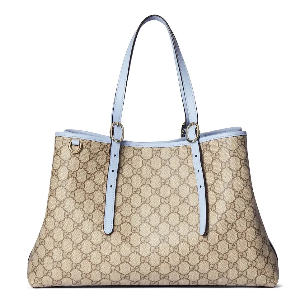 💕💕The GG Emblem series reinterprets the brand’s timeless elegance and exquisite craftsmanship. Inspired by the equestrian world, this tote bag features an adjustable top handle with numbered eyelets. New GG monogram coated fabric in beige and dark brown Light blue leather trim with contrast stitching Light gold tone hardware Red and green webbing cotton lining The bag pictured is sold separately and does not come with the bag charm. Also features D-ring for hanging removable items Adjustable handle with numbered eyelets (height: 21.5 cm - 31.5 cm) Interior: two compartments and one central zipped compartment Magnetic snap closure Ident.: 815213. Dimensions: 38cm (width) x 25cm (height) x 15cm (depth) Weight: about 0.85kg Color: brown pvc/original leather. Made in Italy