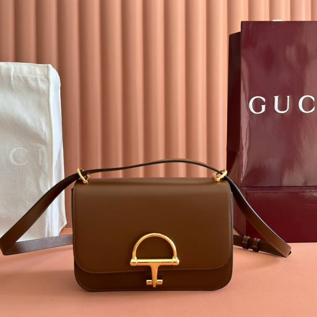 p1640. 💋💋💋【With full set of original counter packaging】2025 autumn and winter series, the Gucci Siena series small shoulder bag continues the evolution of the iconic element of Gucci's classic horsebit. Crafted from fine glossy leather, this shoulder bag has a structured shape and a half-horsebit buckle design from the 1970s. Finished with gold-tone hardware, the interior is lined with three levels of gusseting and a zipped pocket. Black fine glossy leather Gold-tone hardware Black leather lining Interior: 3-level fastening and 1 zipped pocket Shoulder straps: Height: 23cm – 25cm; Length: 127cm Half-horsebit snap fastener Ident: 846705. Dimensions: 22.5cm (width) x 14cm (height) x 8cm (depth) Weight: approx. 0.7kg Color: brown full leather. Made in Italy