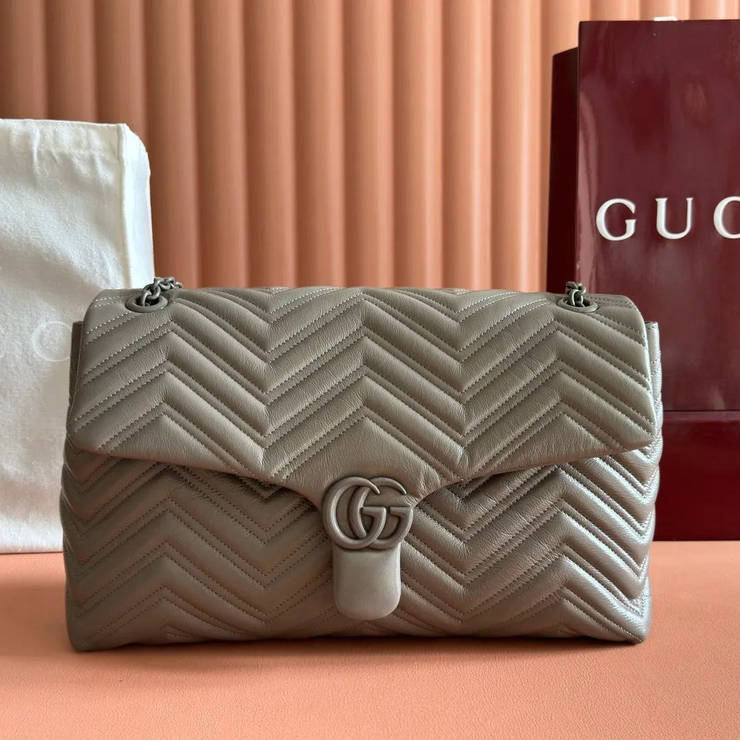 p1960. 💋💋💋【With full set of original counter packaging】2025 autumn and winter series, the brand's iconic GG Marmont series is ingeniously integrated with classic double G elements and faceted chain straps, creating a soft yet crisp silhouette design. This piece is crafted from soft, lightweight quilted V-shaped calfskin leather and features tonal enamel hardware and chain. Black soft lightweight quilted V-shaped calfskin leather. Tonal enamel hardware and chain. Black rayon lining. Double G. Interior: Zippered pocket. Exterior: Back open pocket. Magnetic closure. Ident.: 850659. Dimensions: 37.5cm (W) x 21cm (H) x 9cm (D) Color: Gray/Soft Leather. Made in Italy