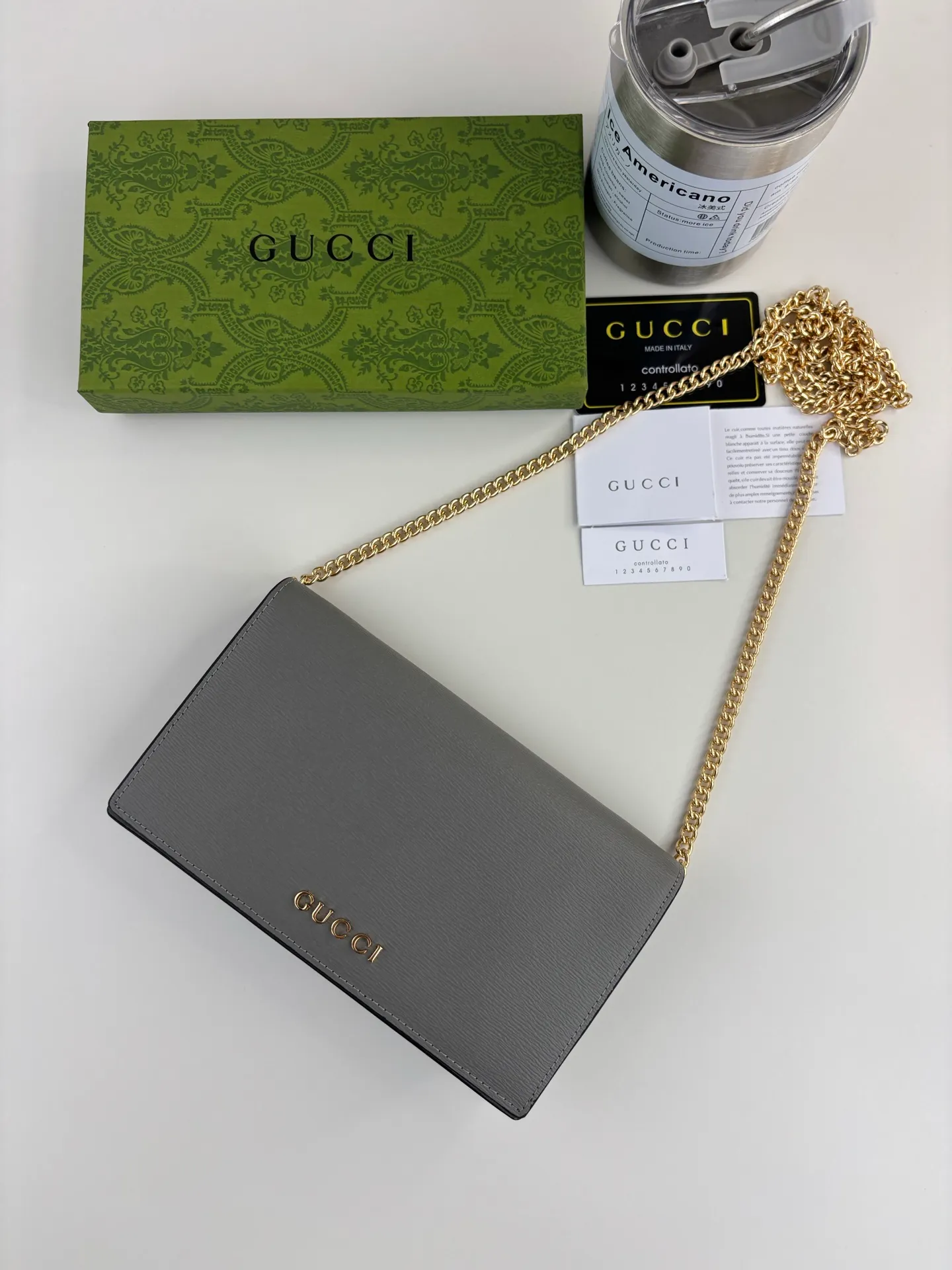 💰230 GUCCl chain wallet with handwritten Gucci logo. The small leather accessories series seamlessly integrates modern fashion elements to create ingenious items with changing styles without losing classic connotation, bringing fresh vitality to formal leather items. This chain wallet is crafted from gray leather and features the Gucci logo in gold-tone script. Gray leather, gold-tone hardware, taffeta lining, scripted Gucci logo detail, interior: six card compartments, one flat pocket, one zipped gusset pocket and one open compartment, chain strap, snap-stud fastening. Style number: 772643 Size: 20cm x 12.5cm x 4cm Color: Gray