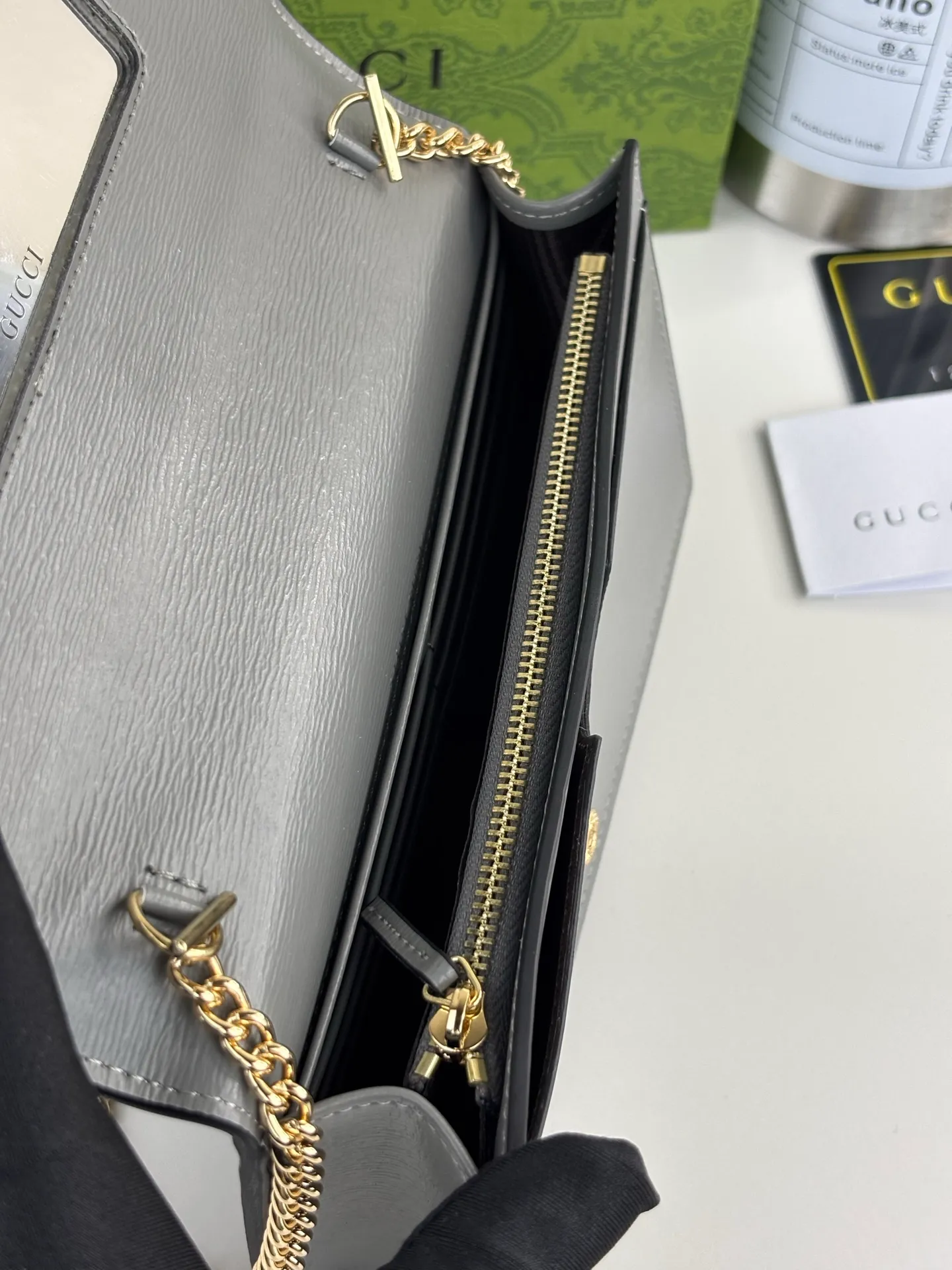 💰230 GUCCl chain wallet with handwritten Gucci logo. The small leather accessories series seamlessly integrates modern fashion elements to create ingenious items with changing styles without losing classic connotation, bringing fresh vitality to formal leather items. This chain wallet is crafted from gray leather and features the Gucci logo in gold-tone script. Gray leather, gold-tone hardware, taffeta lining, scripted Gucci logo detail, interior: six card compartments, one flat pocket, one zipped gusset pocket and one open compartment, chain strap, snap-stud fastening. Style number: 772643 Size: 20cm x 12.5cm x 4cm Color: Gray