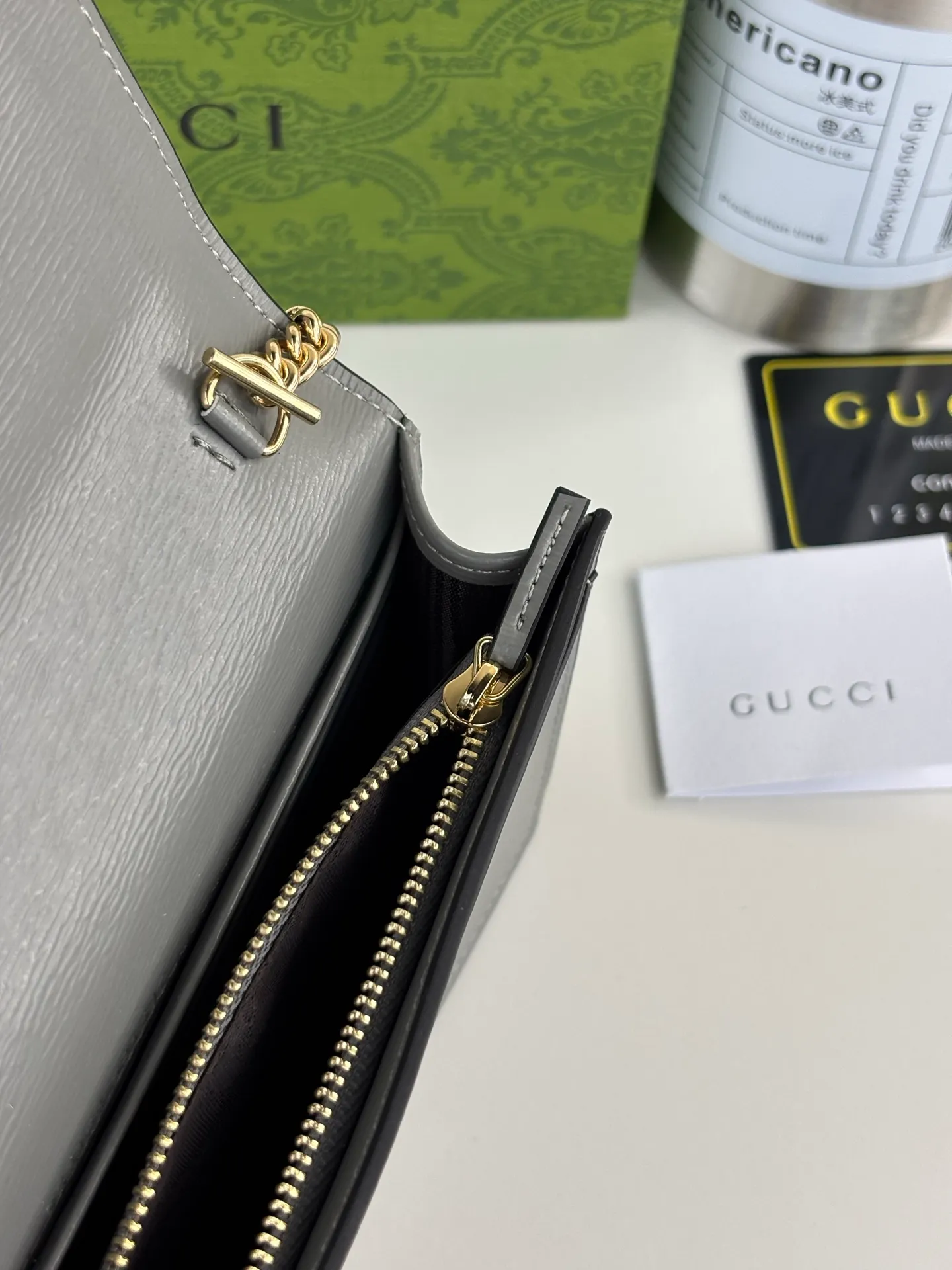 💰230 GUCCl chain wallet with handwritten Gucci logo. The small leather accessories series seamlessly integrates modern fashion elements to create ingenious items with changing styles without losing classic connotation, bringing fresh vitality to formal leather items. This chain wallet is crafted from gray leather and features the Gucci logo in gold-tone script. Gray leather, gold-tone hardware, taffeta lining, scripted Gucci logo detail, interior: six card compartments, one flat pocket, one zipped gusset pocket and one open compartment, chain strap, snap-stud fastening. Style number: 772643 Size: 20cm x 12.5cm x 4cm Color: Gray