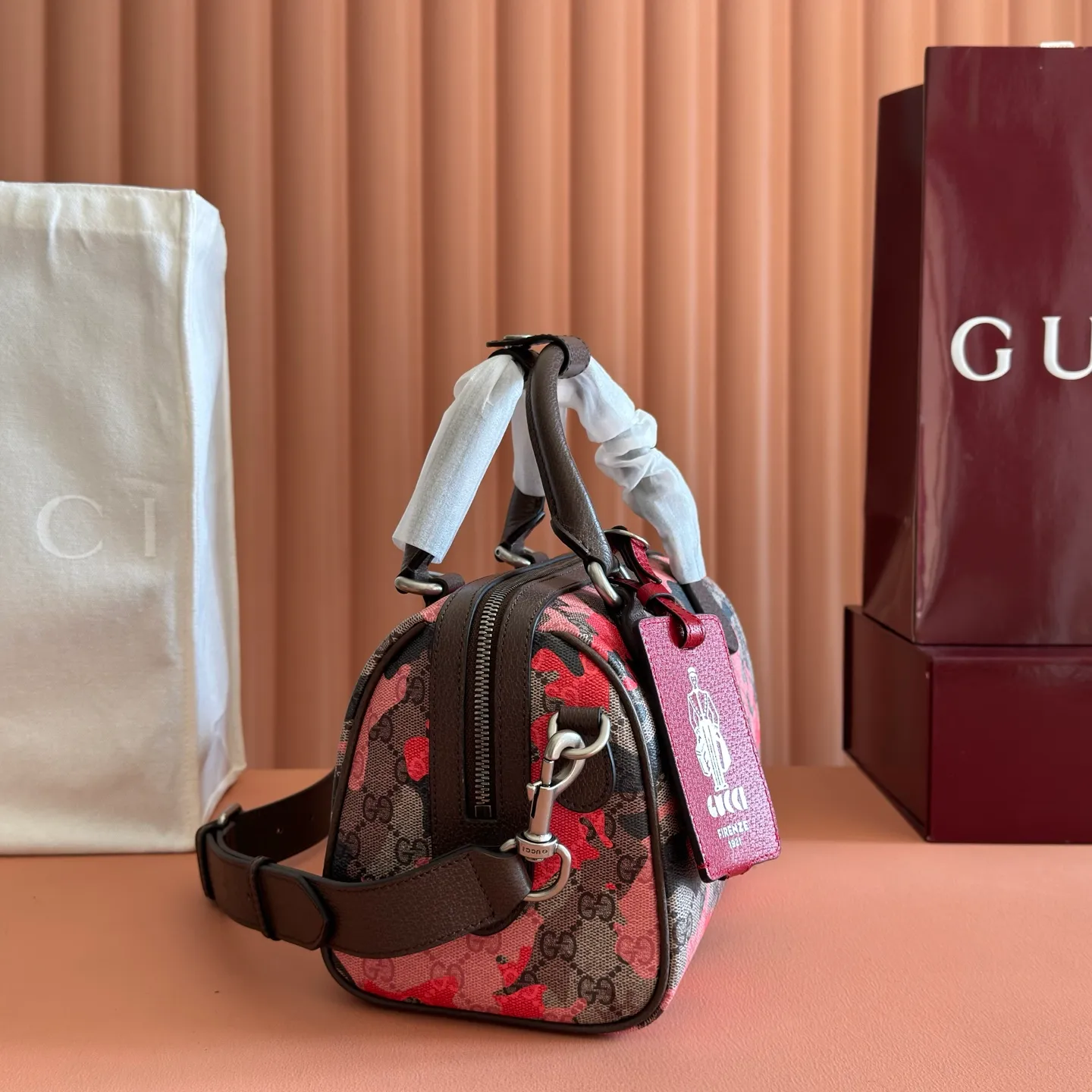 p1240💋💋💋【Original configuration counter complete package】Vivid camouflage combined with unique color matching, a new interpretation of the classic GG pattern. This travel bag is crafted from coated fabric with a marbled GG monogram pattern and features a matching ID plaque. Coated fabric with pink and red camouflage marbled GG monogram Brown, pink and red leather trim Palladium-toned hardware Unique cotton and linen lining Double G Interior: 1 zip pocket External: 1 removable bellman ID tag Handle height: 11 cm Removable and adjustable leather shoulder strap (height: 110 cm - 128 cm) Zip closure Ident No.: 854860. Dimensions: 25cm (width) x 16cm (height) x 14cm (depth) Weight: approx. 856g Color: camouflage pink/PVC.