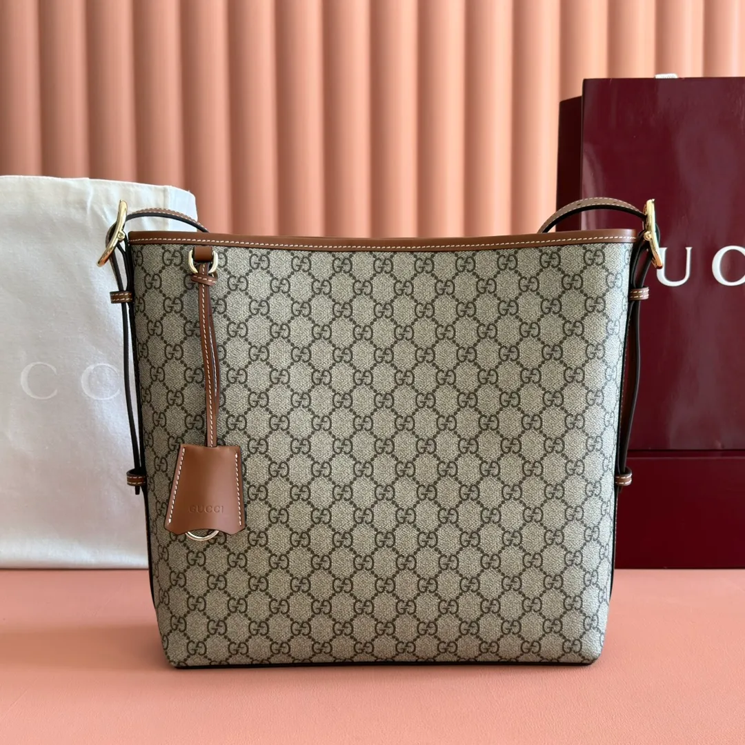p1120. 💋💋💋【With full set of original counter packaging】💕The GG Emblem series reinterprets the brand's timeless elegance and exquisite craftsmanship. Lined in webbed cotton, this bucket bag features an internal compartment for added functionality. Beige and dark brown GG monogram coated fabric Brown leather trim Light gold tone hardware Webbing cotton lining Interior: Zip pocket Adjustable leather shoulder strap: Height: 26 cm - 47 cm; Length: 102 cm Magnetic closure Ident No.: 847452. Dimensions: 30.5cm (width) x 30.5cm (height) x 9cm (depth) Weight: approx. 0.85kg Color: Brown/PVC.