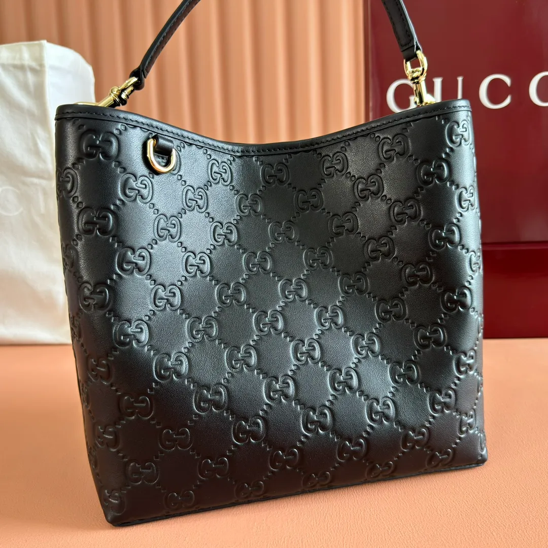 p1320. 💋💋💋Original leather configuration with full counter packaging [New product] GG Emblem series reinterprets the brand's timeless elegance and exquisite craftsmanship. Lined in webbed cotton, this bucket bag features an internal compartment for added functionality. Black GG printed embossed leather Light gold tone hardware Black cotton and linen blend lining Top handle with hook closure (height: 18cm) Additional D-ring for attaching removable items Interior: two compartments and a central snap-stud compartment Detachable and adjustable leather shoulder strap (height: 54cm - 60cm; length: 105cm - 115cm) Magnetic snap closure Weight: approx. 700g. Model: 815103. Dimensions: 25 cm (width) x 25 cm (height) x 15.5 cm (depth) Color: black embossed/original leather. Made in Italy