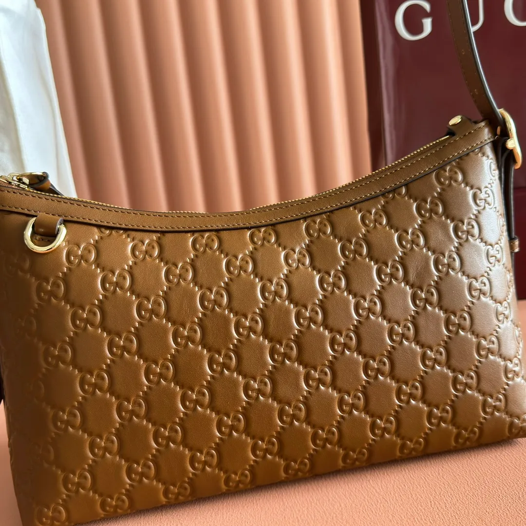 p1140. 💋💋💋"With full set of original counter packaging" [New Product] 2025 Autumn and Winter Series, the GG Emblem series reinterprets the brand's timeless elegance and exquisite craftsmanship. This shoulder bag is crafted from GG embossed leather, showing off its exquisite texture. Gucci Rosso Ancora GG printed embossed leather Light gold tone accessories Gucci Rosso Ancora cotton lining The bag pictured is sold separately and does not come with the bag charm. Interior: Zippered pocket Adjustable leather shoulder strap: Height: 16 cm - 26 cm; Length: 72 cm Zipper closure Ident: 847449. Dimensions: 30cm (W) x 19cm (H) x 11cm (D) Weight: Approx. 0.45kg Color: Brown embossed. Made in Italy