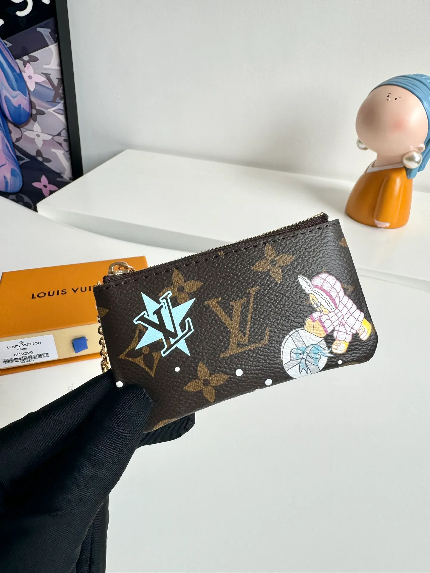 P320🇫🇷Exclusive real shot of overseas original single M12229! This key bag is made of Monogram canvas, depicting the brand's mascot Vivienne pushing a snowball in playful brushstrokes, with a glittering polar bear pattern reflected on the back. The keychain and Vivienne-shaped zipper add dazzling sparkle, making them ideal gifts for Vivienne collectors. Size: 12×7×1.5cm