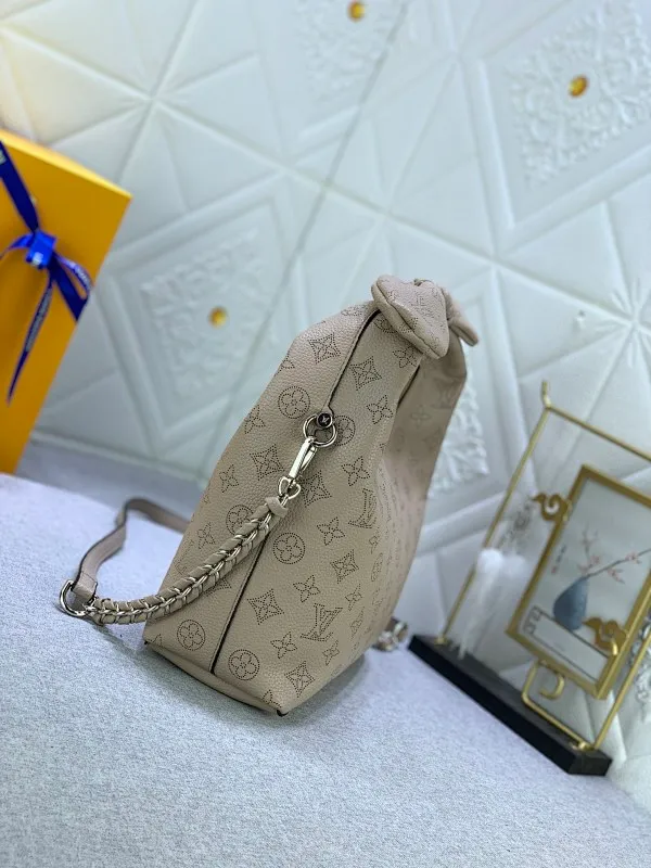 All categories Official website "Brand Women's Bags" Women's Bags 💙 LV Why Knot small handbag is made of Louis Vuitton's iconic Monogram engraved and perforated cow leather, combined with a knot-shaped handle, exuding a gentle style and modern atmosphere. Functional design holds everyday essentials such as a cell phone, wallet, keys, and sunglasses, and the removable woven leather chain allows for easy shoulder wear.