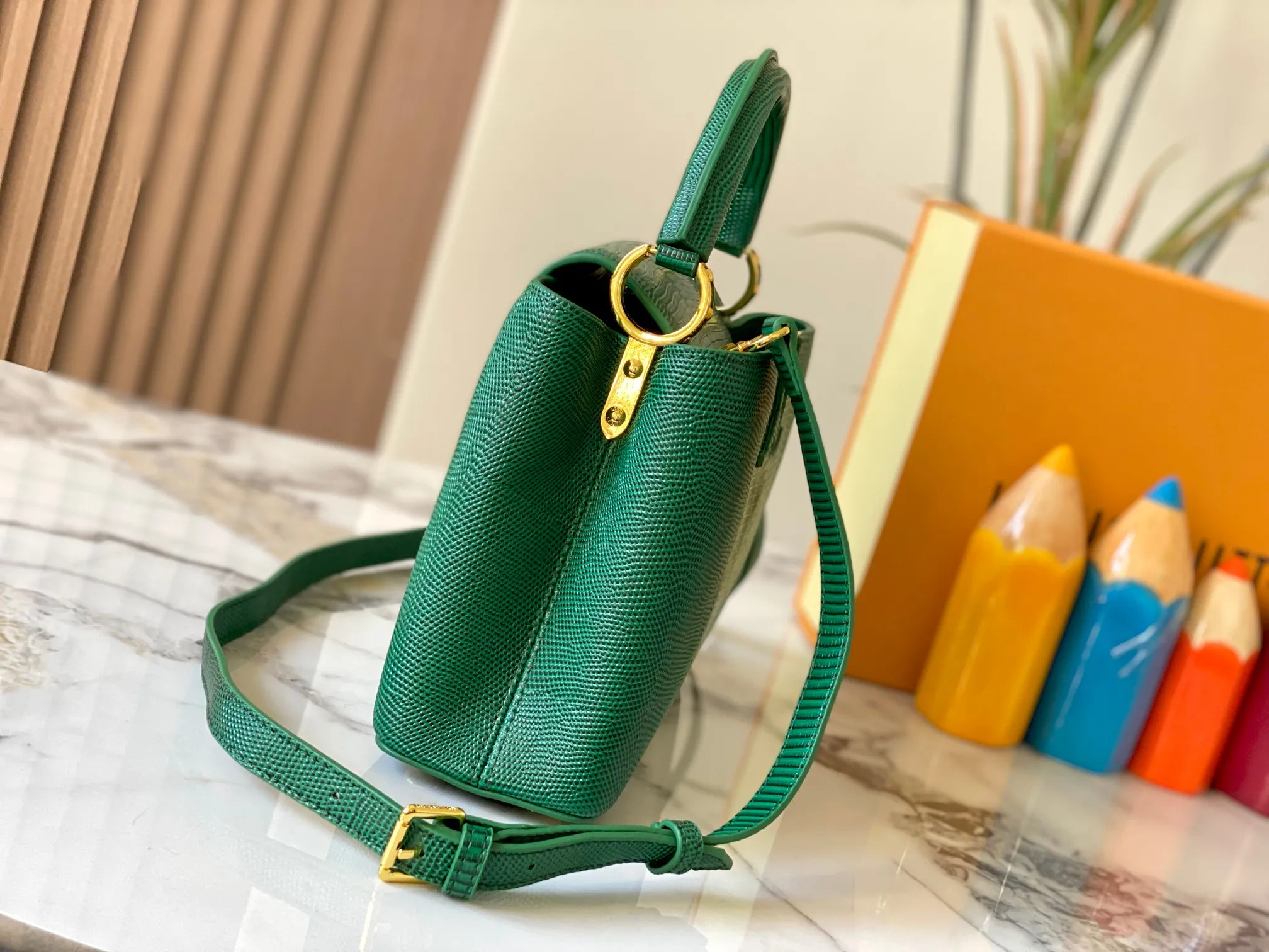 Top original P440 Guangzhou-made M99528 green lizard skin gold buckle CapucinesBB handbag exquisitely combines graceful lizard skin outer layer, delicate sheepskin lining and glossy metal parts. The iconic flap makes two styles fashionable. The LV logo can be read on the inside and Monogram flowers bloom on the outside. It can light up an eye-catching corner for evening occasions and add a personalized atmosphere to the wardrobe. Shine gorgeous style in day and night occasions.  Detailed features 27 x 18 x 9 cm (length x height x width)
