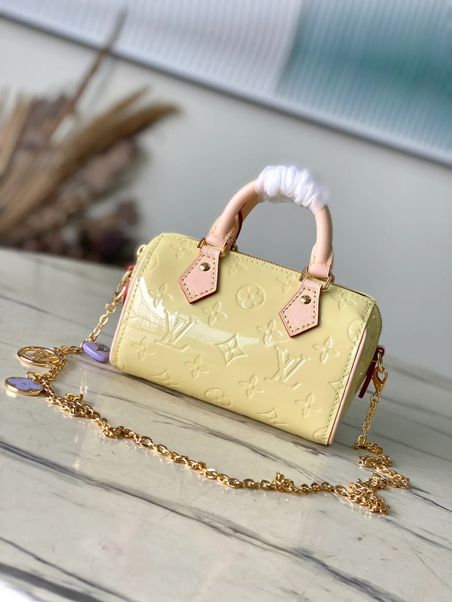 💰1020 (top layer leather) top original order M83000 yellow. This Nano Speedy handbag is made of Monogram Vernis pastel patent leather. It is a mini version of the brand's most famous travel bag. The bright patent leather is embossed with the Monogram pattern and features a natural leather top handle. The detachable gold chain strap is embellished with a charm and is the perfect size for mobile phones and small wallets. Dimensions: 16 x 10 x 7.5 cm (length x height x width)