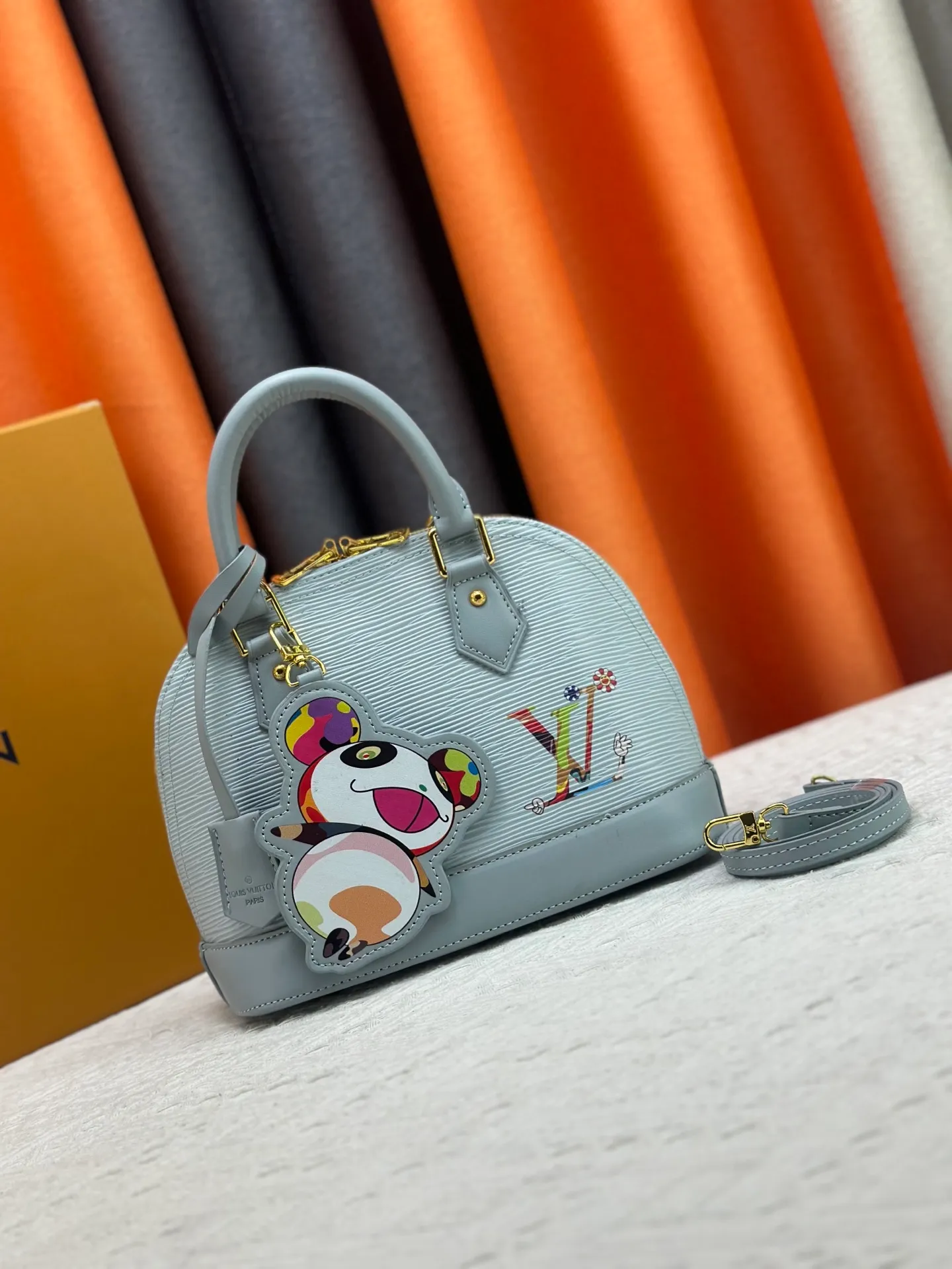 p300 Upgraded original M13670 M14197 M53152 This Alma BB handbag is made of Epi leather and appears in the Louis Vuitton x Murakami reissue series. The smart LV letters on the front reflect the Japanese artist's "ultra-flat" aesthetic, which contrasts with the removable distinctive panda decoration. Top handles, a removable shoulder strap and a dazzling padlock complete the Art Deco design. Dimensions: 23.5 x 17.5 x 11.5 cm (length x height x width)