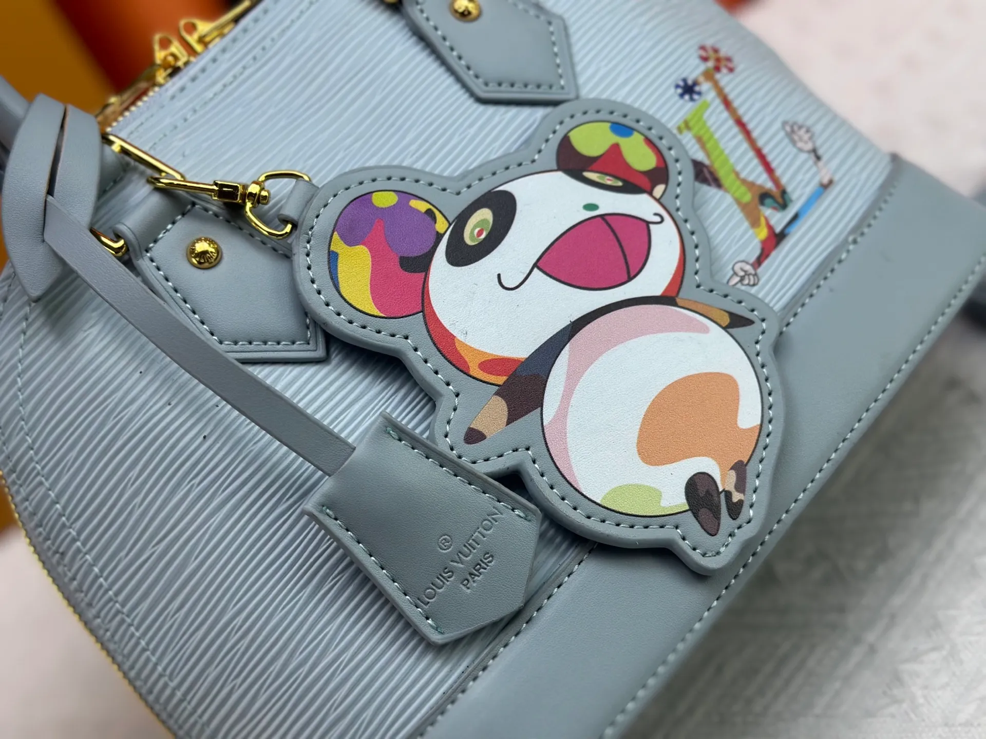 p300 Upgraded original M13670 M14197 M53152 This Alma BB handbag is made of Epi leather and appears in the Louis Vuitton x Murakami reissue series. The smart LV letters on the front reflect the Japanese artist's "ultra-flat" aesthetic, which contrasts with the removable distinctive panda decoration. Top handles, a removable shoulder strap and a dazzling padlock complete the Art Deco design. Dimensions: 23.5 x 17.5 x 11.5 cm (length x height x width)