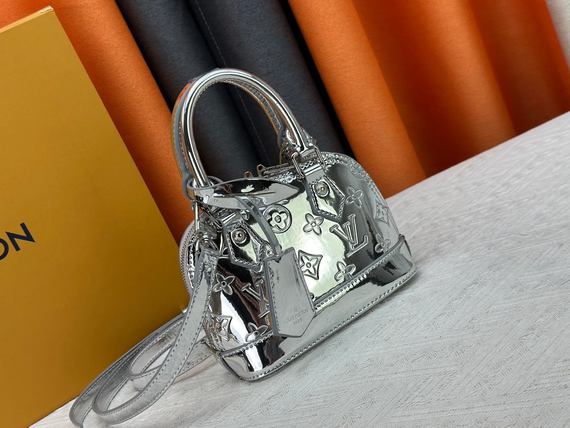 P280 M11835 M53152 82717 90611 The Alma mini handbag of the LVSki series draws inspiration from the Louis Vuitton archive hard box, rendering a new Monogram Miroir effect on the Monogram embossed coated canvas, highlighting the concept of retro futurism. Spacious interior patch pockets ensure organized storage. Size: 18x12x8cm