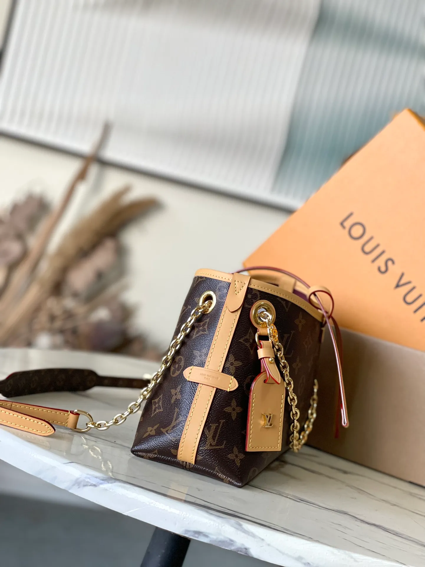 💰760 Top original order M13014 This CarryAll BB handbag is made of Monogram canvas, with Monogram flowers on the dazzling chain, lighting up day and night occasions with a trendy look. A leather name tag complements the lace-up closure, and an interior zippered pocket provides easy access to credit cards. Dimensions: 26 × 17 × 10 cm