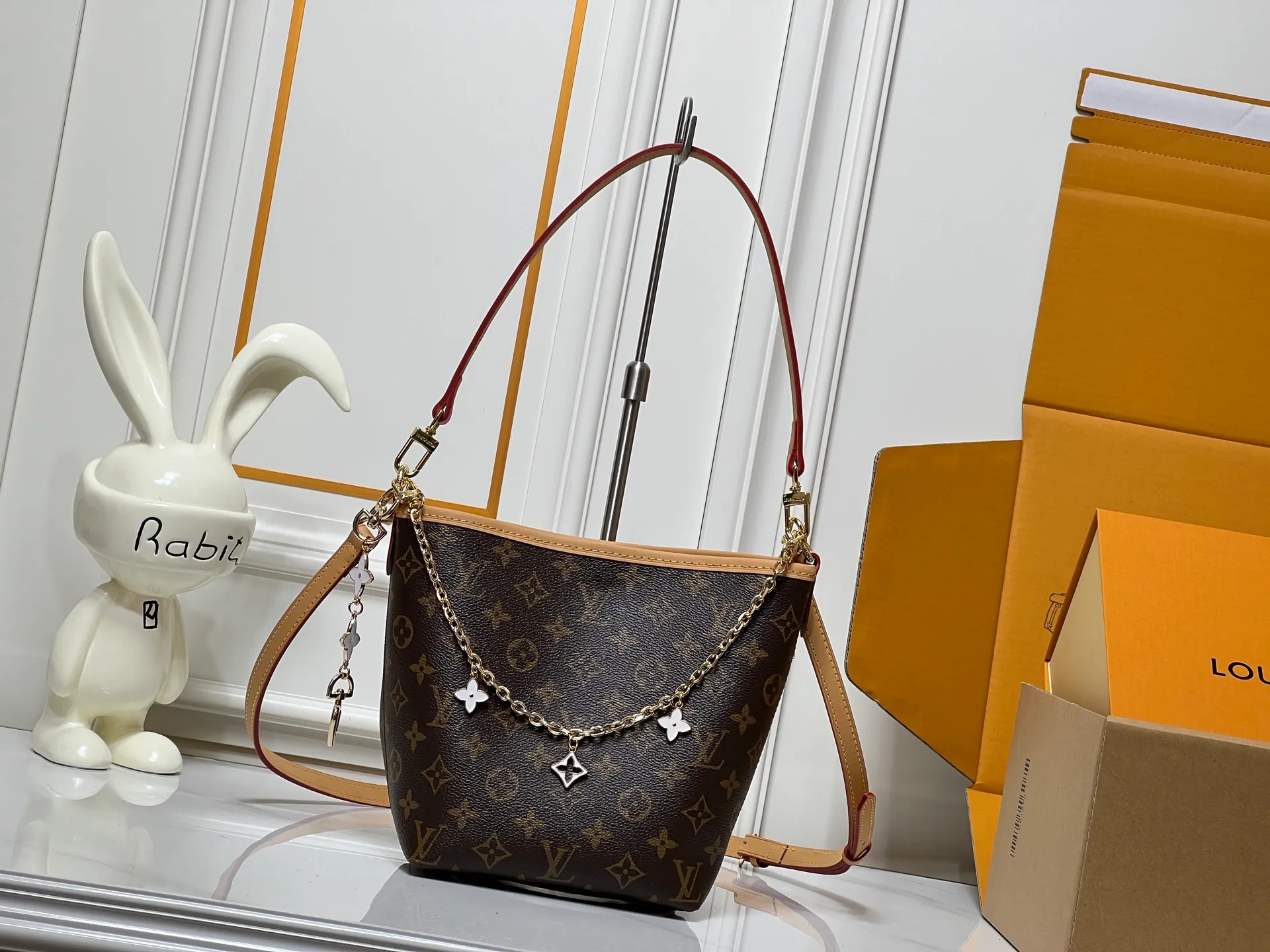 Batch 300💰M25666 All In BB Handbag It is made of the iconic Monogram presbyopic canvas, and the bag shape is simple yet stylish. Paired with a red leather shoulder strap, it can be worn on one shoulder or across the body, and can be carried flexibly. The body of the bag is also decorated with metal chain charms with brand elements and flower shapes, which adds a sense of sophistication and design to the whole. It not only retains the classic charm of LV, but also shows a unique fashion style through detailed design. It is a good choice to enhance the style and texture in daily matching. Size: 17x20x15cm