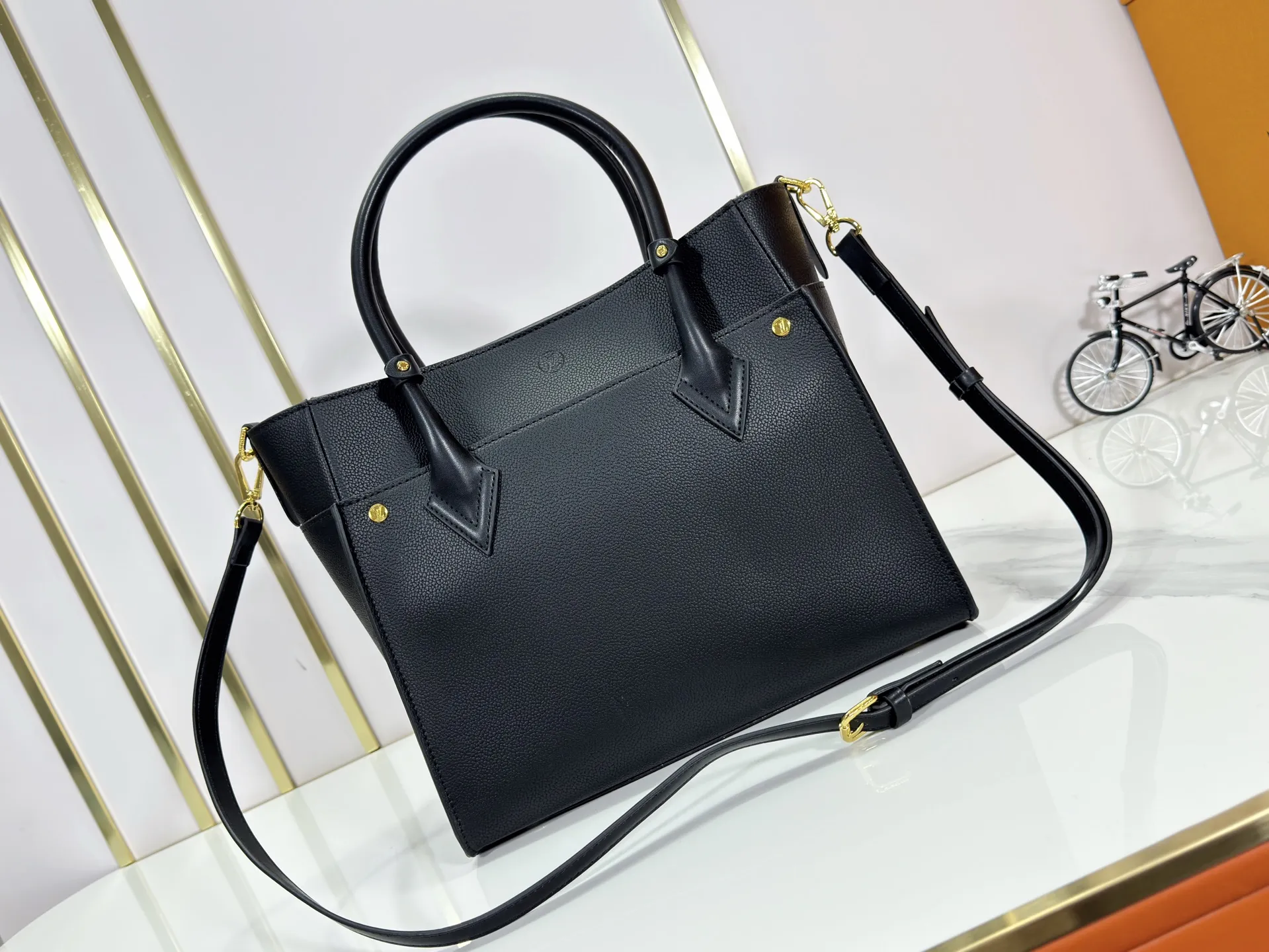P340 upgraded original M53826 M53825 M53824 M53823On My Side handbag shows the elegant fusion of calfskin and classic Monogram canvas. Contrasting canvas shapes the large outer pocket, creating a trompe l'oeil effect as if two handbags merge into one. Plenty of space can easily accommodate office needs, and the adjustable shoulder strap allows for a cross-body style. Dimensions: 30.5 x 24.5 x 14 cm (Length x Height x Width) - Calfskin and Monogram coated canvas - Cowhide leather trim - Microfiber lining - 2 top handles for hand or elbow carry - Adjustable shoulder strap for shoulder or cross-body wear - Lock closure - 2 outer pockets with magnetic closure - Zip pocket - 1 patch pocket