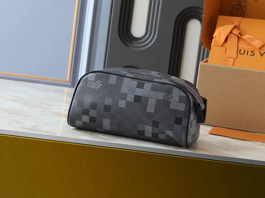 💰200💰Upgraded from the original M15109 M47528. This Dopp Kit toiletry bag is made of deep Damoflage Black canvas with leather trim, releasing a modern edge. Double zippers and leather handles allow for quick access to toiletries, and the washable lining adds functionality. The Marque L.Vuitton Déposée logo is nestled in the plaid pattern, highlighting the brand's identity. Dimensions: 15 x 16.5 x 28 cm (H x W x Length)