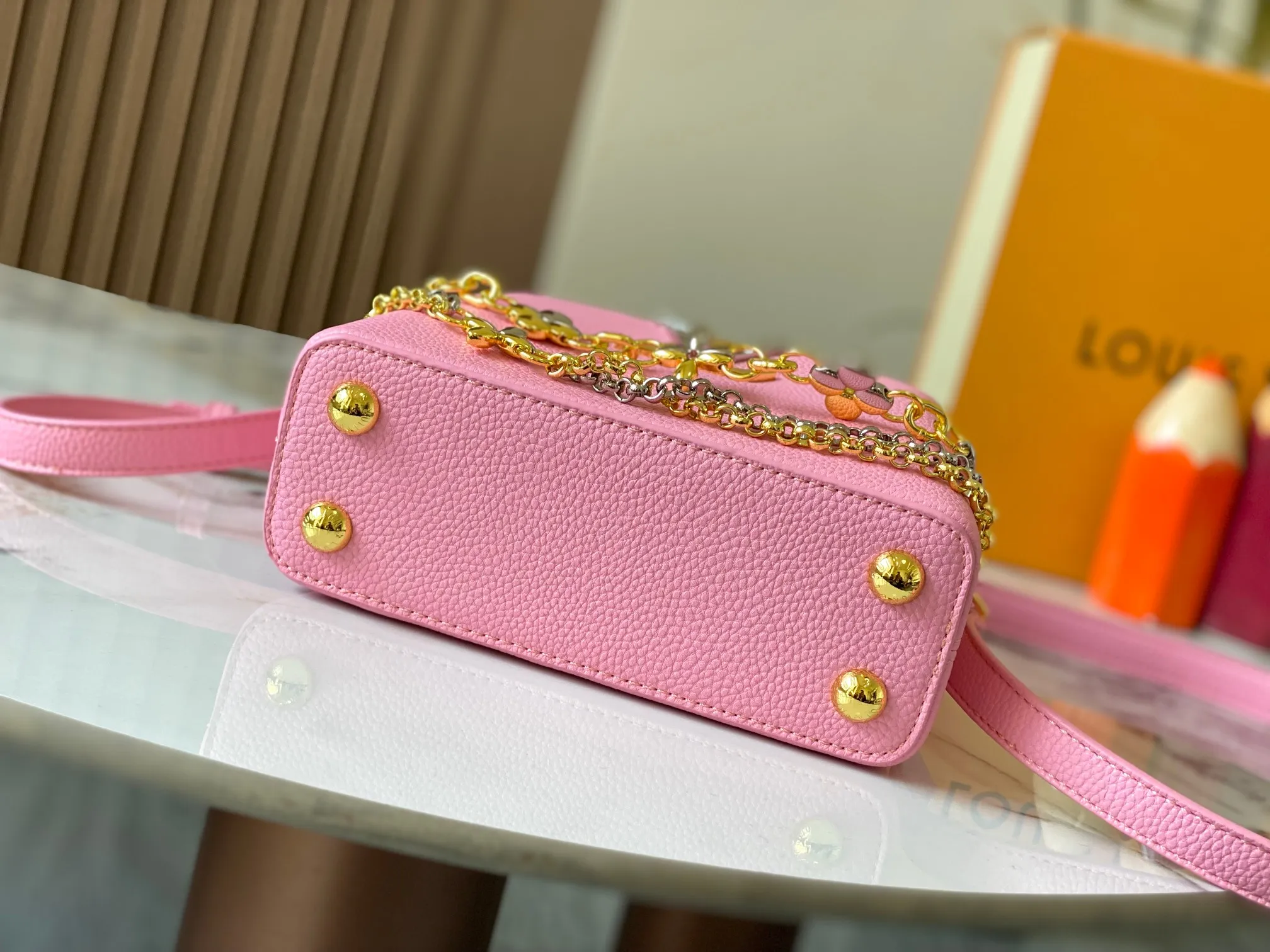 P480 [Guangzhou top quality original version] M26351 Pink This modern version of Capucines mini is made of timeless Taurillon leather and equipped with a jewelry-inspired Infinity chain. The bag is decorated with double galvanized metal parts, including the iconic Monogram floral pattern, and the LV Initials logo created with sunburst technology, creating a sundial-like light and shadow effect. The bag has multiple pockets and a detachable shoulder strap, allowing it to be carried on one shoulder or across the body. 14 x 8 x 21 cm (height x width x length)