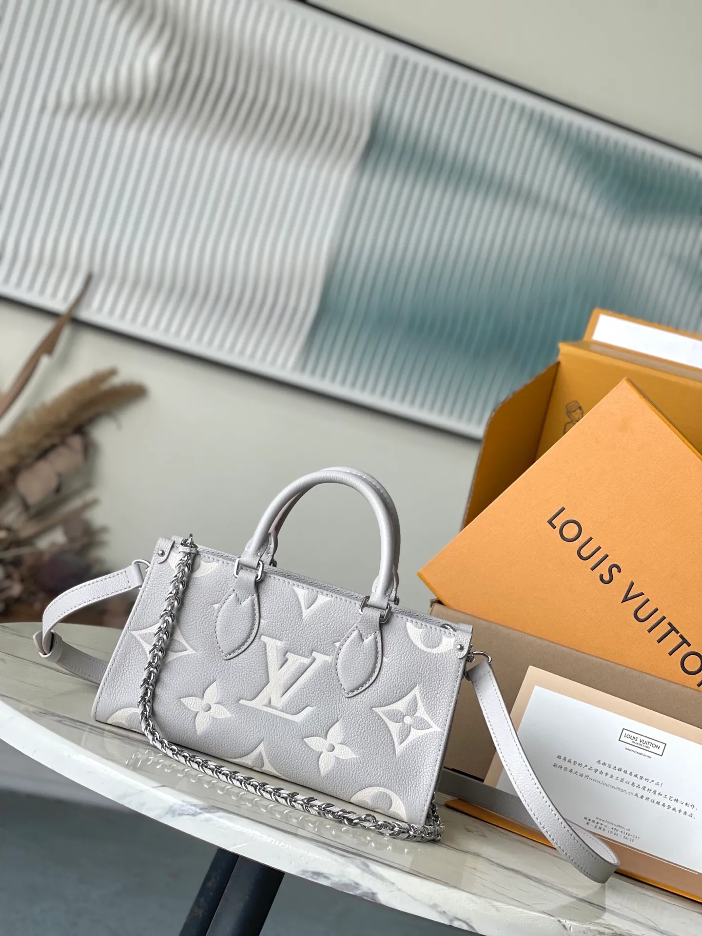💰1040 (top-grain leather) top original order M14213 This OnTheGo East West handbag is from the LVMilky Way series. The iconic Monogram Empreinte leather is dyed in seasonal colors, complementing the shiny metal parts and detachable braided chain. The inner and outer compartments can store daily needs in an orderly manner. The compact structure is easy to carry in a variety of ways. Dimensions: 25 × 13 × 10 cm