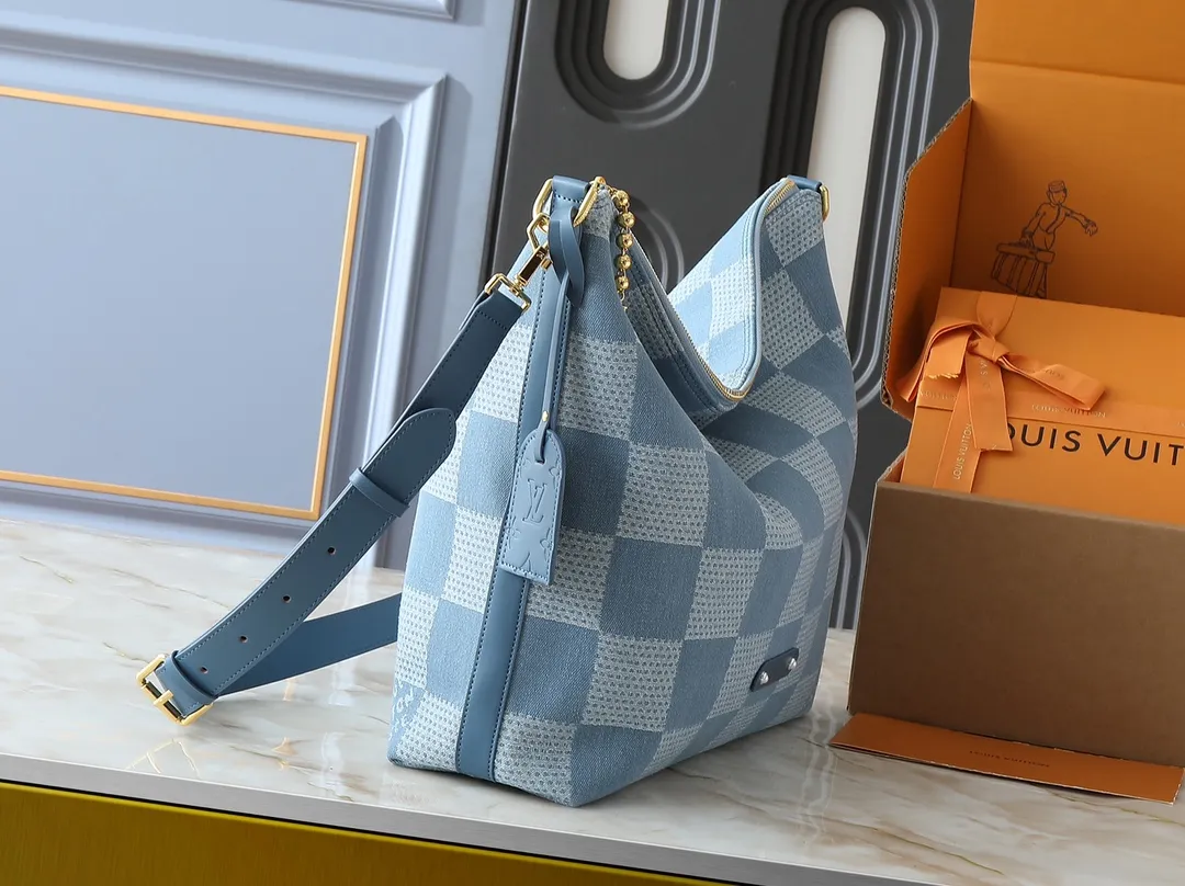 💰280💰Upgraded original N00202 M14018 This Vagabond Hobo handbag is made of Damier Denim 3D cotton canvas with cow leather trim and dazzling metal parts, and is embellished with a soft cotton lining with a gorgeous woven label. The Marque L.Vuitton Déposée logo and metallic beaded zip pullers showcase Pharrell Williams' signature design elements. Dimensions: 38.0 x 35.0 x 12.0 cm (length x height x width)