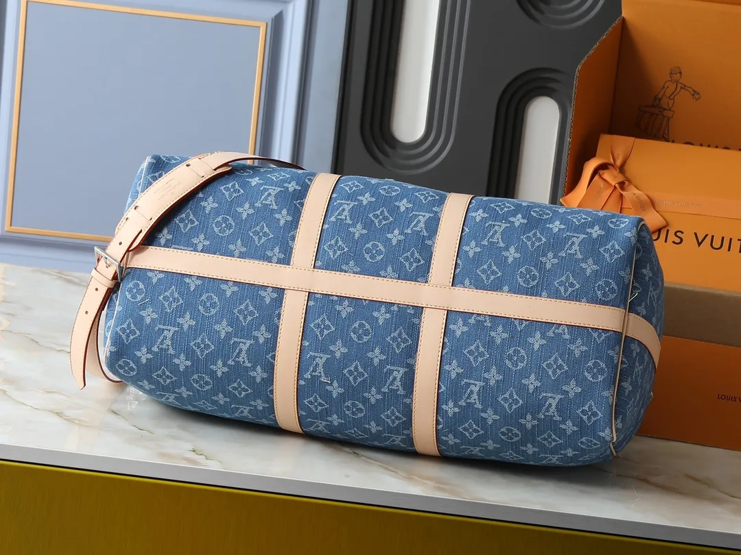 💰380💰Upgraded from the original M24315 M41416 This KEEPALL BANDOULIÈRE 50 travel bag This Keepall Bandoulière travel bag uses Monogram Denim fabric to deliver a dynamic and fashionable atmosphere. The Monogram pattern is laid out on certified canvas fabric dyed in denim tones, creating an eye-catching visual contrast with the cowhide leather trim. Paired with a padlock and detachable strap, it's a perfect choice for short trips. Dimensions: 50 x 29 x 22 cm