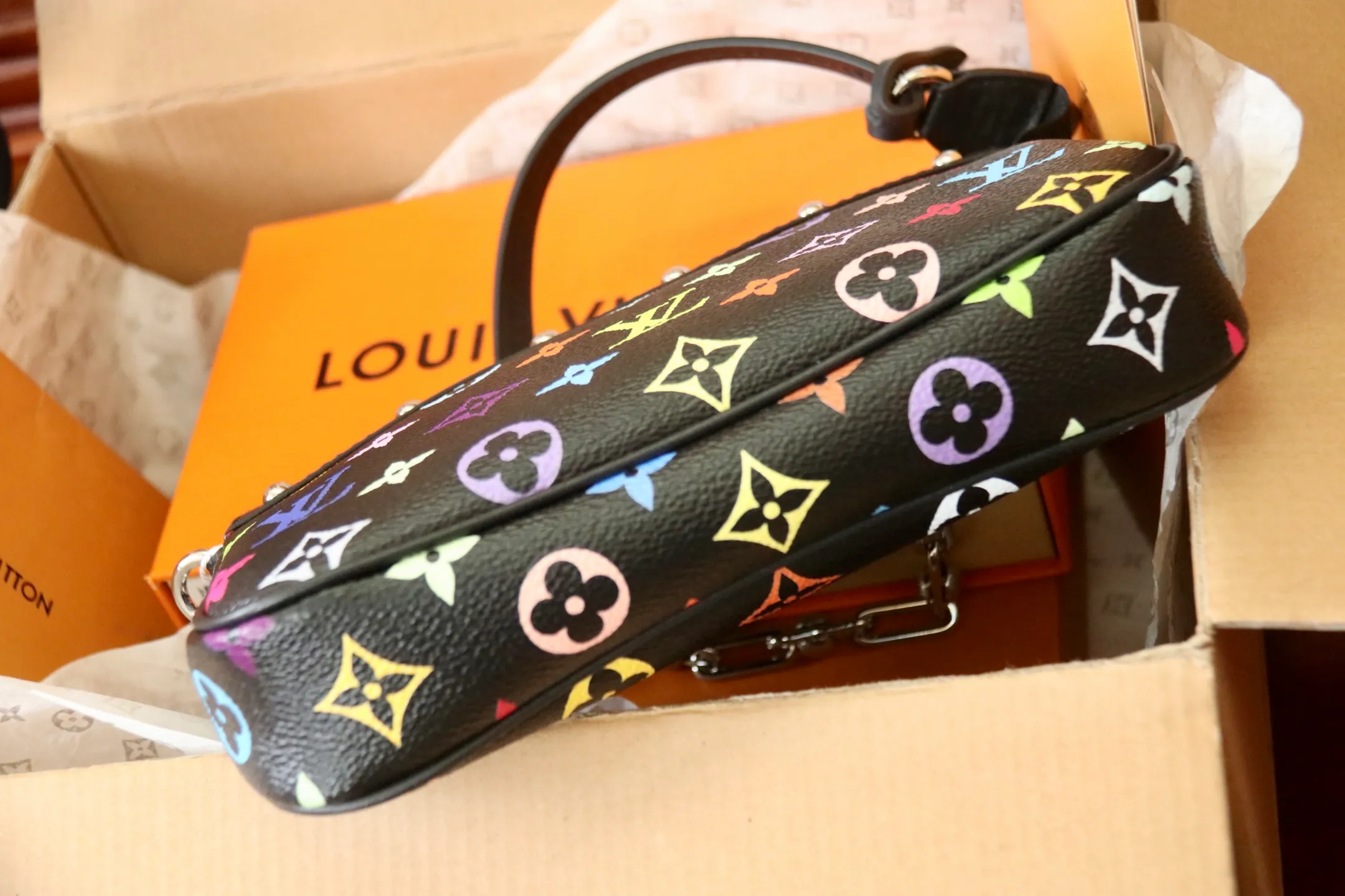 The top original P720 M13404 black Pochette Accessoires handbag is made of coated canvas and uses colorful Monogram patterns to interpret the smart style of the Louis Vuitton x Murakami cross-border collaboration series. Calf leather trim and dazzling hardware add to the sophisticated details, while the detachable shoulder strap and chain allow for flexible carry. 13 x 4 x 22 cm (height x width x length)