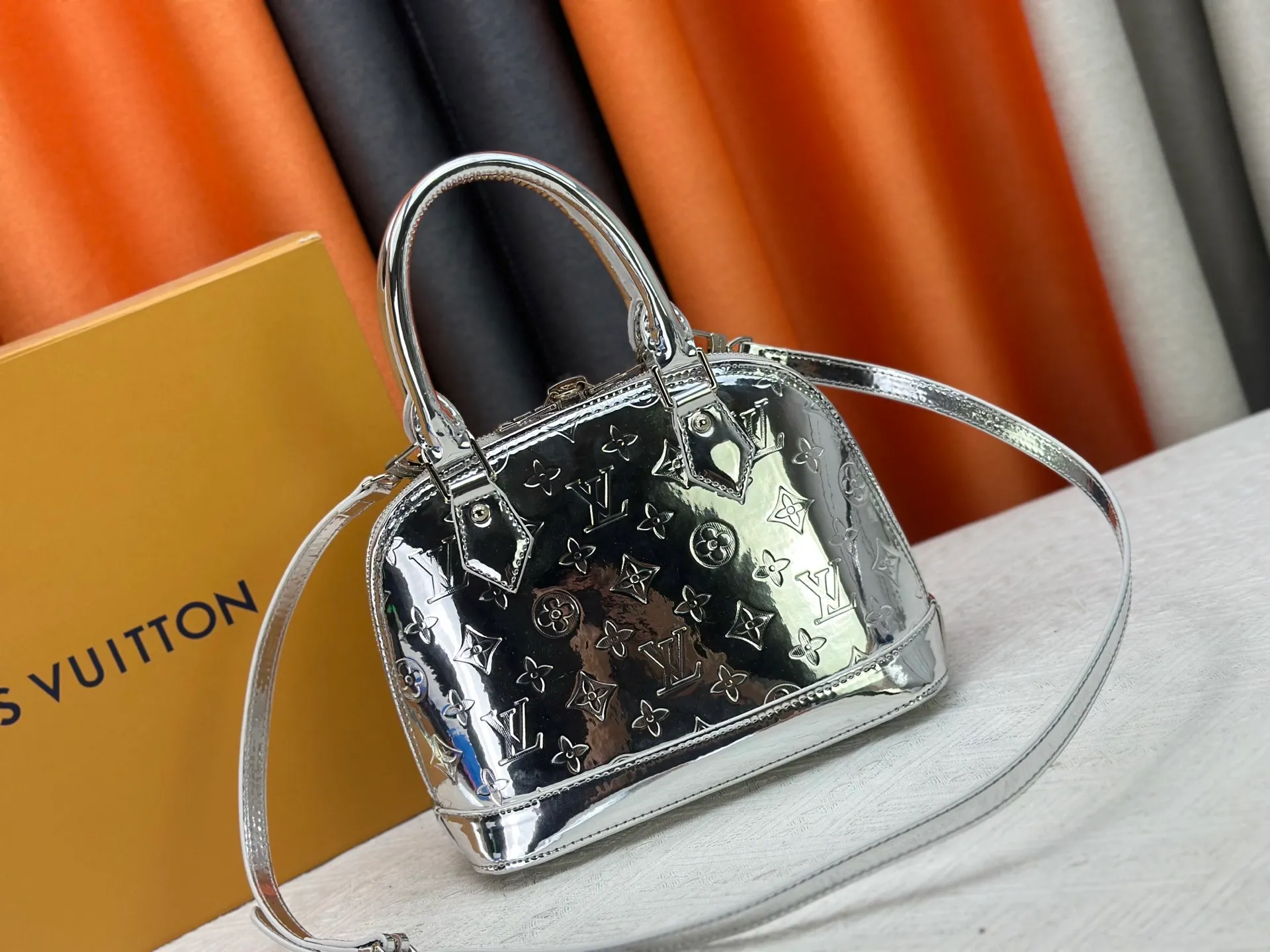P300 M11835 M53151 M53152 The Alma medium handbag of the LVSki series draws inspiration from the Louis Vuitton archive hard box, rendering a new Monogram Miroir effect on the Monogram embossed coated canvas, highlighting the concept of retro futurism. Spacious interior patch pockets ensure organized storage. Size: 23.5x17.5x11.5cm