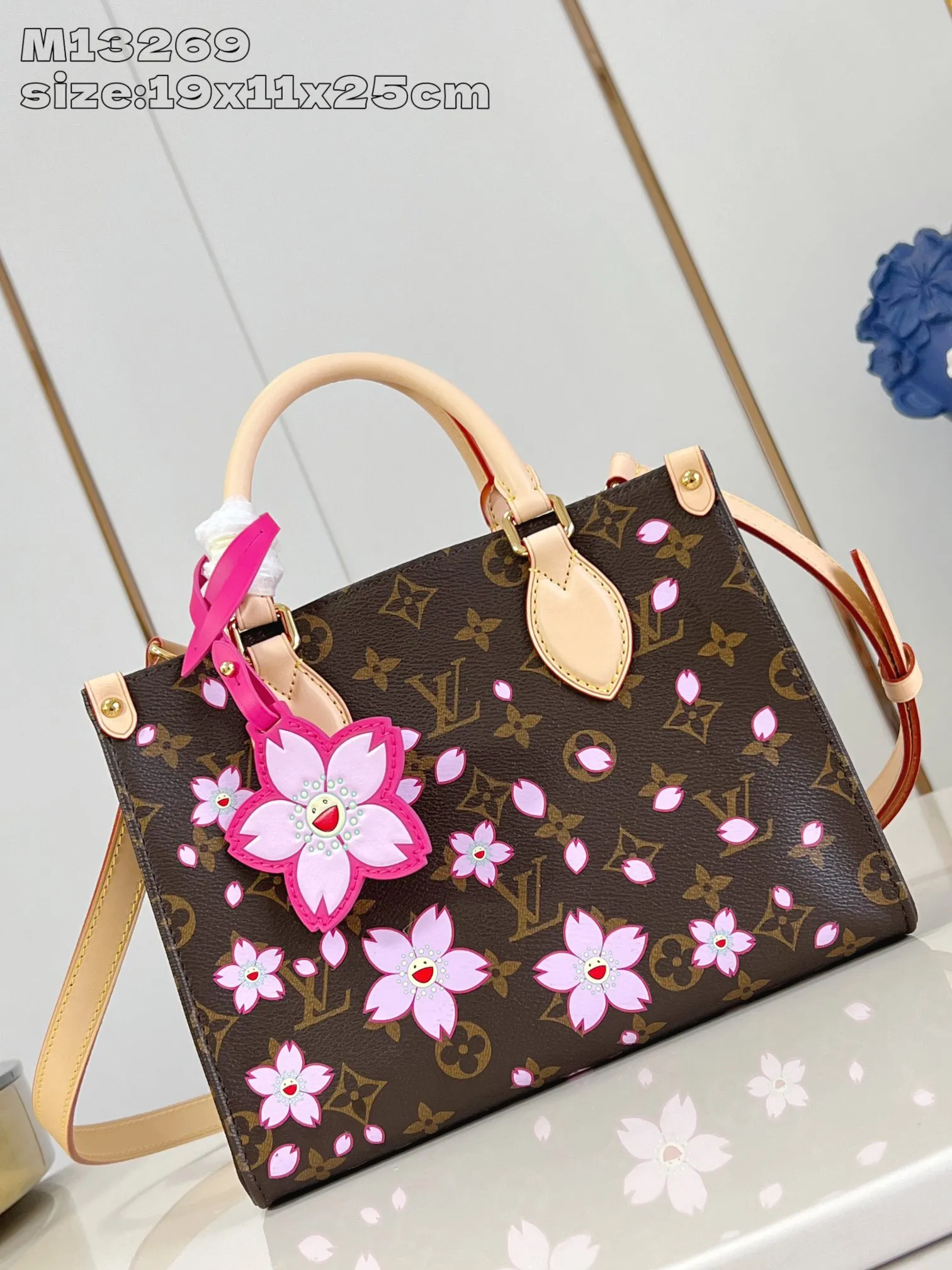 💰1100 (Steel Hardware) Top Original Order M13269] This small OnTheGo handbag comes from the Louis Vuitton x Takashi Murakami replica series, renewing the classic design with a bright Cherry Blossom pattern. Monogram coated canvas accentuates a floral pattern that symbolizes rebirth, while cowhide leather trim and dazzling hardware add to the sophisticated style. Removable Cherry Blossom embellishments add a new twist. 19 x 11.5 x 25 cm (height x width x length)