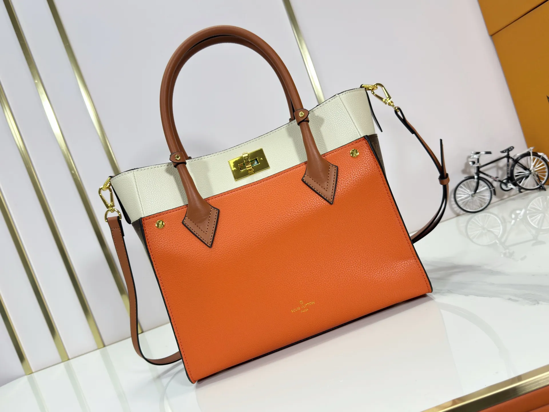 P340 upgraded original M53826 M53825 M53824 M53823On My Side handbag shows the elegant fusion of calfskin and classic Monogram canvas. Contrasting canvas shapes the large outer pocket, creating a trompe l'oeil effect as if two handbags merge into one. Plenty of space can easily accommodate office needs, and the adjustable shoulder strap allows for a cross-body style. Dimensions: 30.5 x 24.5 x 14 cm (Length x Height x Width) - Calfskin and Monogram coated canvas - Cowhide leather trim - Microfiber lining - 2 top handles for hand or elbow carry - Adjustable shoulder strap for shoulder or cross-body wear - Lock closure - 2 outer pockets with magnetic closure - Zip pocket - 1 patch pocket