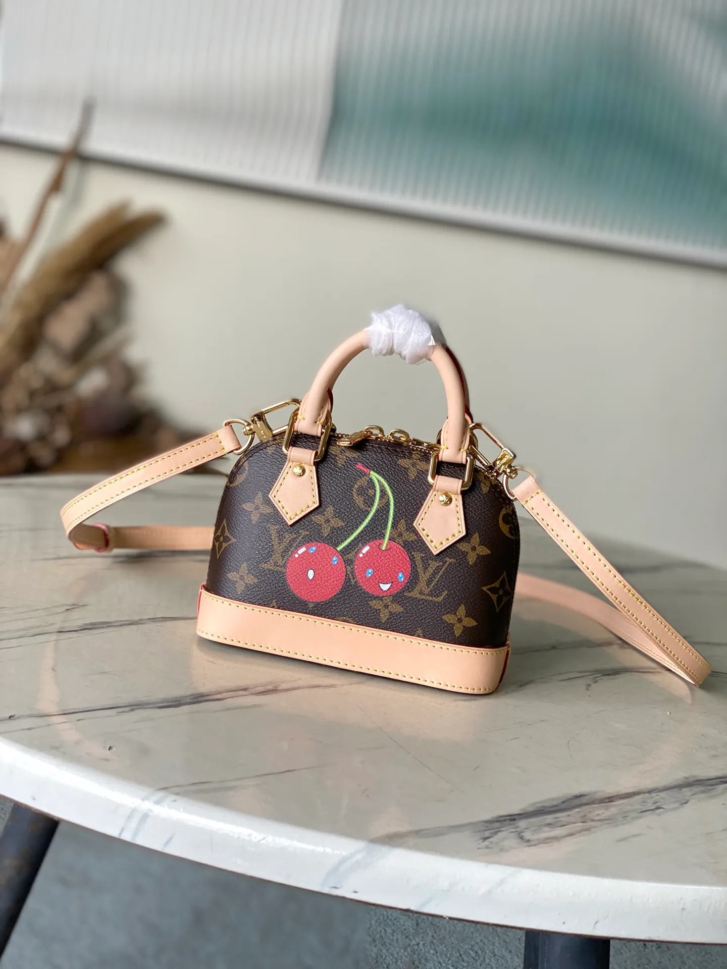 💰960 Top Original Order M13416 This Nano Alma handbag combines Monogram coated canvas and cow leather trim, making the exquisite silhouette show the cherry pattern of the Louis Vuitton × Murakami replica series. The top handle and detachable and adjustable shoulder strap allow for a variety of carrying methods, and the internal space can accommodate daily needs such as a short wallet and a large smartphone. Dimensions: 18 × 12 × 8 cm