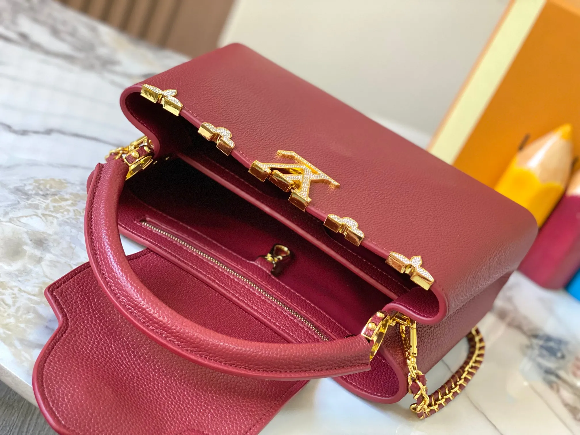 Top original P480 Guangzhou product M24585 maroon and gold diamond corolla 🔺This Capucines Flower Crown handbag is made of full-grain Taurillon leather embellished with Monogram flowers. Each flower is shaped by exquisite crystal diamonds. The LV logo and flowers echo each other, making this soft handbag reveal a jewel-like luster. Use the detachable shoulder strap cleverly to switch between shoulder and crossbody at will♠️Size: 31.5 * 20 * 11cm🥂